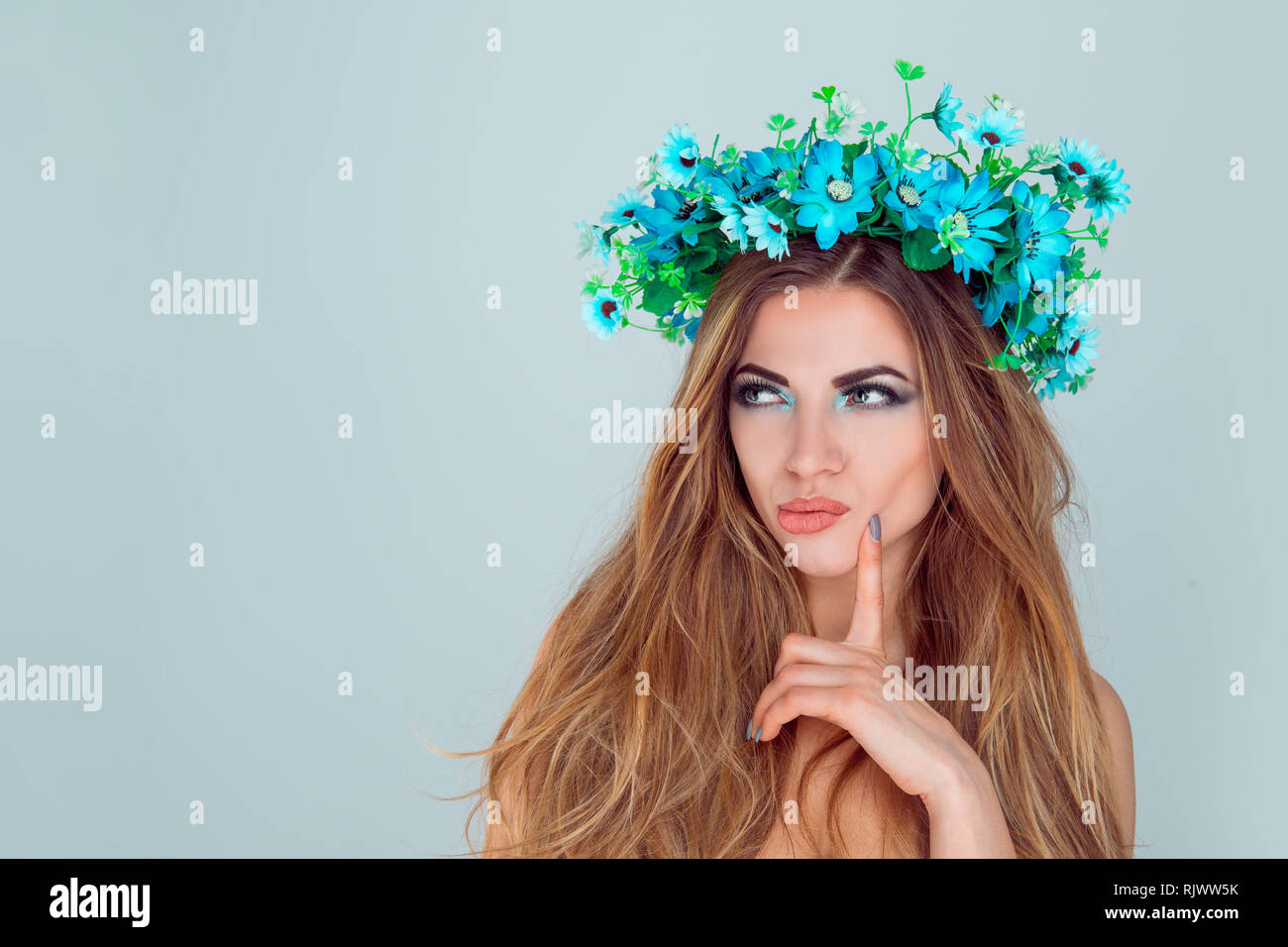 Scettico sospettoso giovane donna con archetto floreali Foto Stock