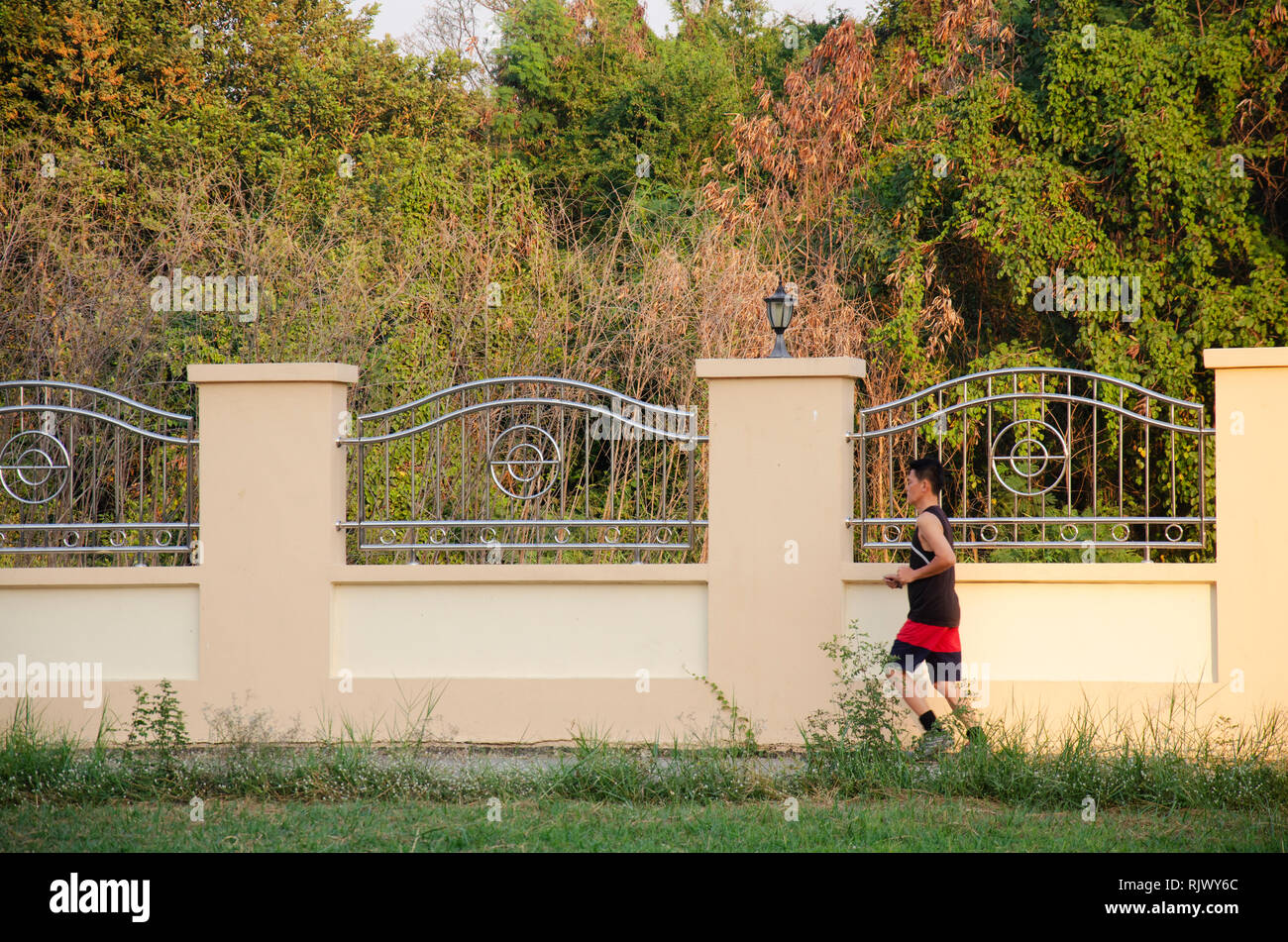 Asian thai le persone che eseguono il jogging ed esercitare nel crepuscolo tempo in giardino pubblico park il 17 febbraio 2017 a Nonthaburi, Tailandia. Foto Stock