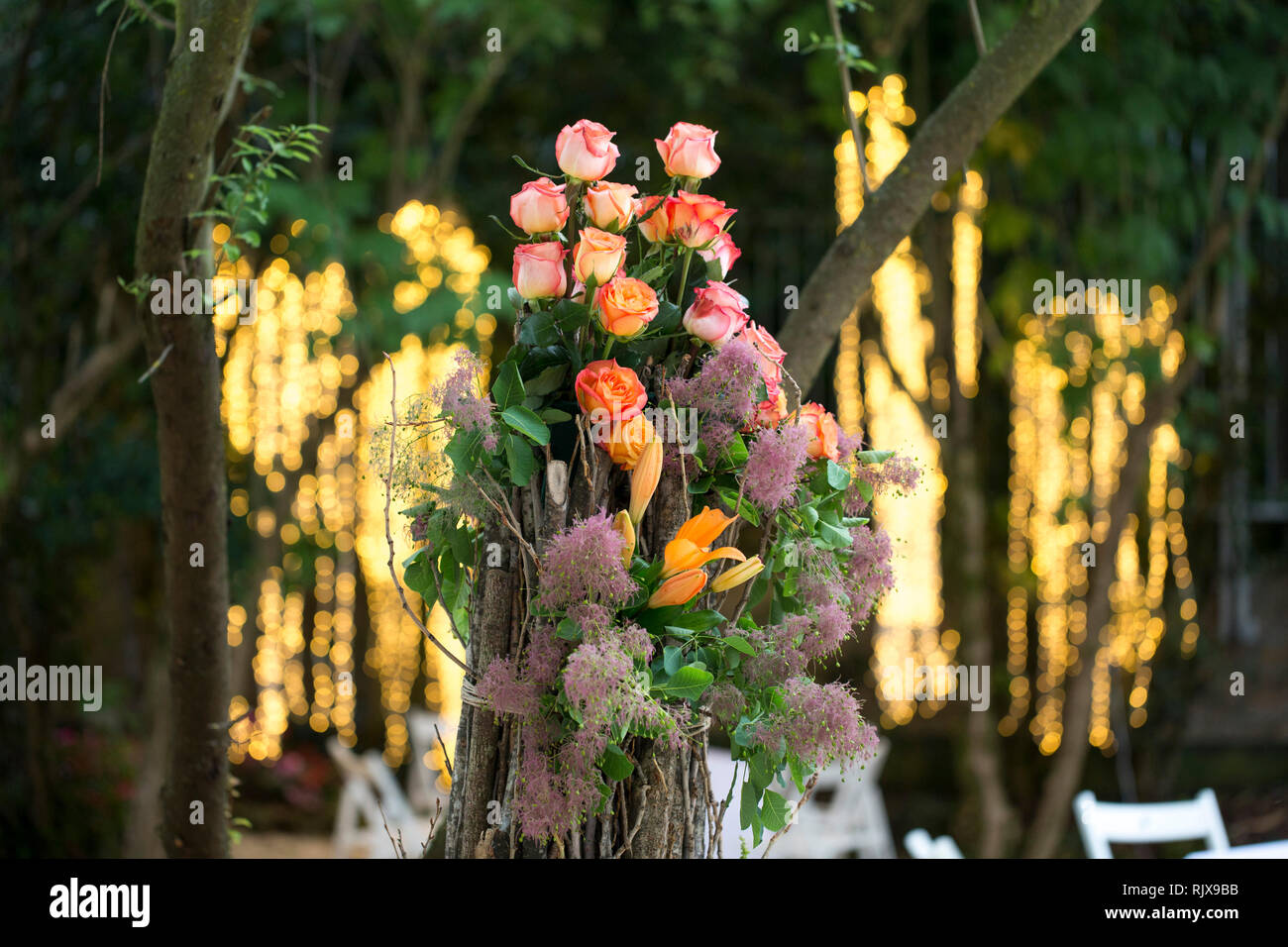 Primo piano di una molla party di nozze, fiore centrotavola con una cascata di luci dietro il tavolo. Foto Stock