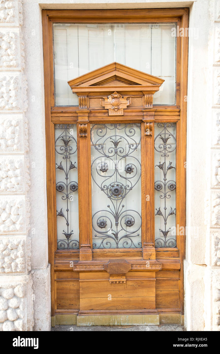 Massiccia porta di legno su una bianca facciata in marmo Foto Stock