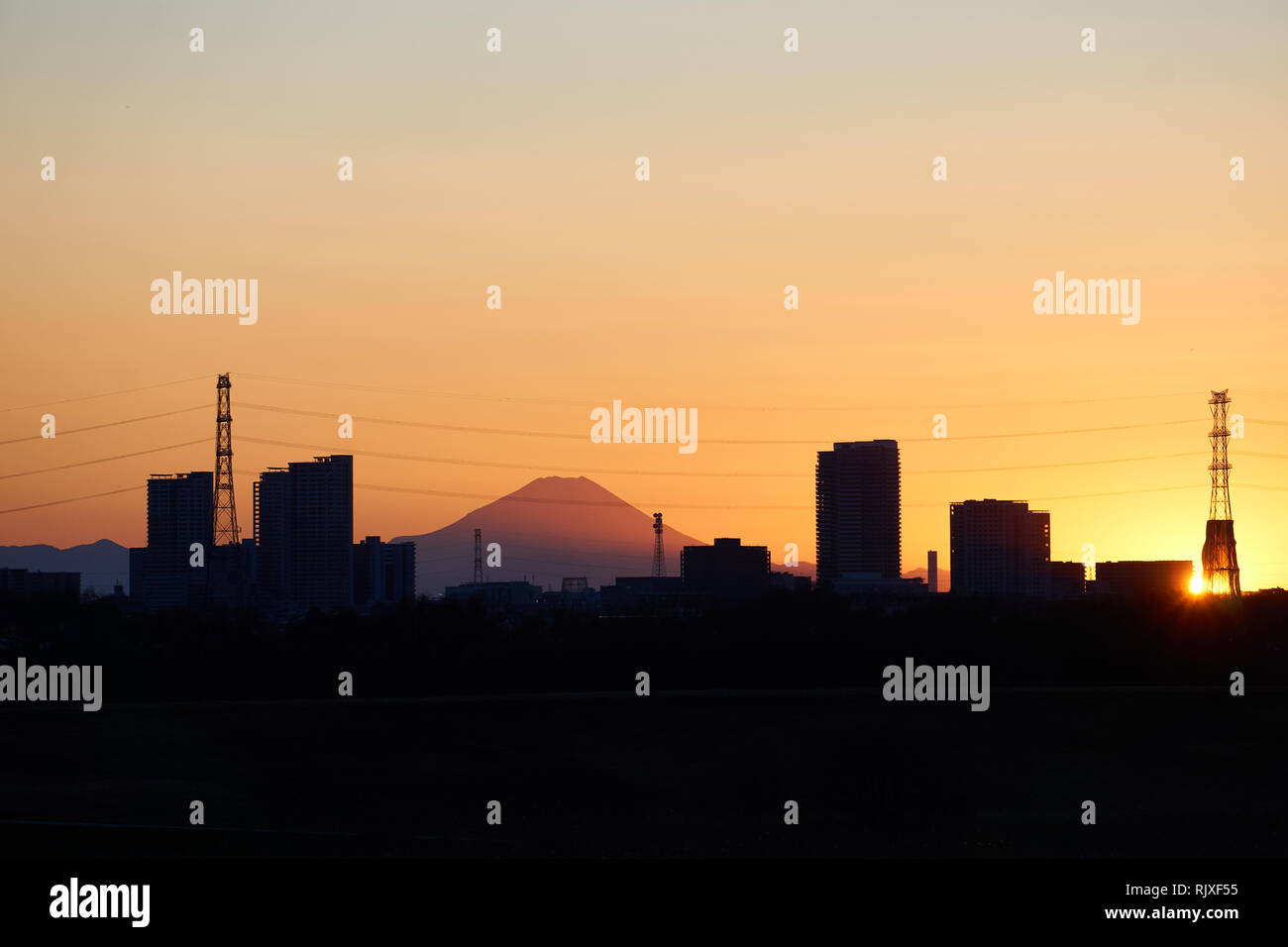 Il monte Fuji in Giappone al tramonto con il grattacielo torri e le linee di alimentazione che lo circonda Foto Stock