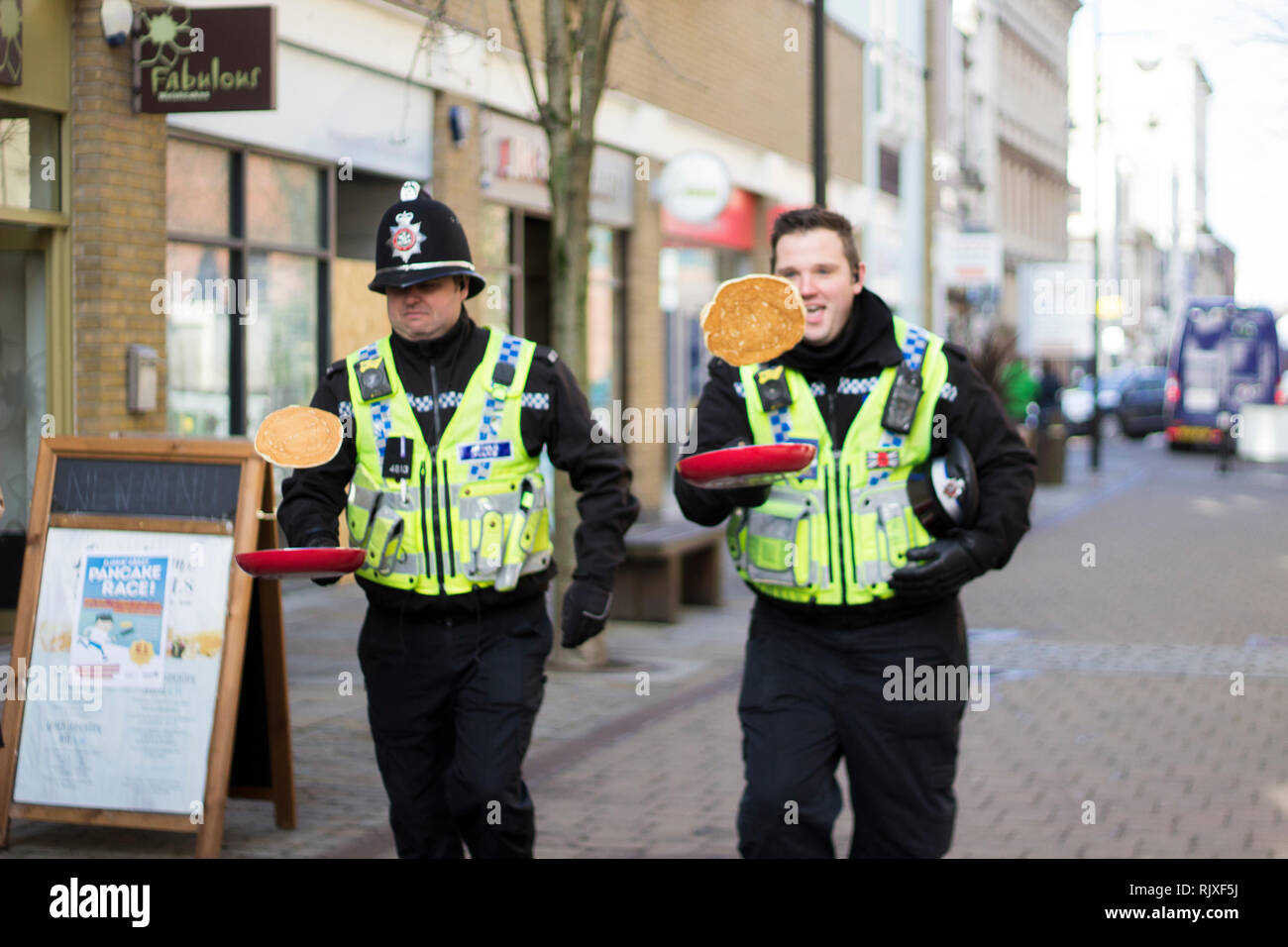 CARDIFF, Galles. Il 12 febbraio 2017. Due poliziotti in competizione in una frittella di capovolgimento di gara. Corse da della crêpe fuga nella Baia di Cardiff. Foto Stock