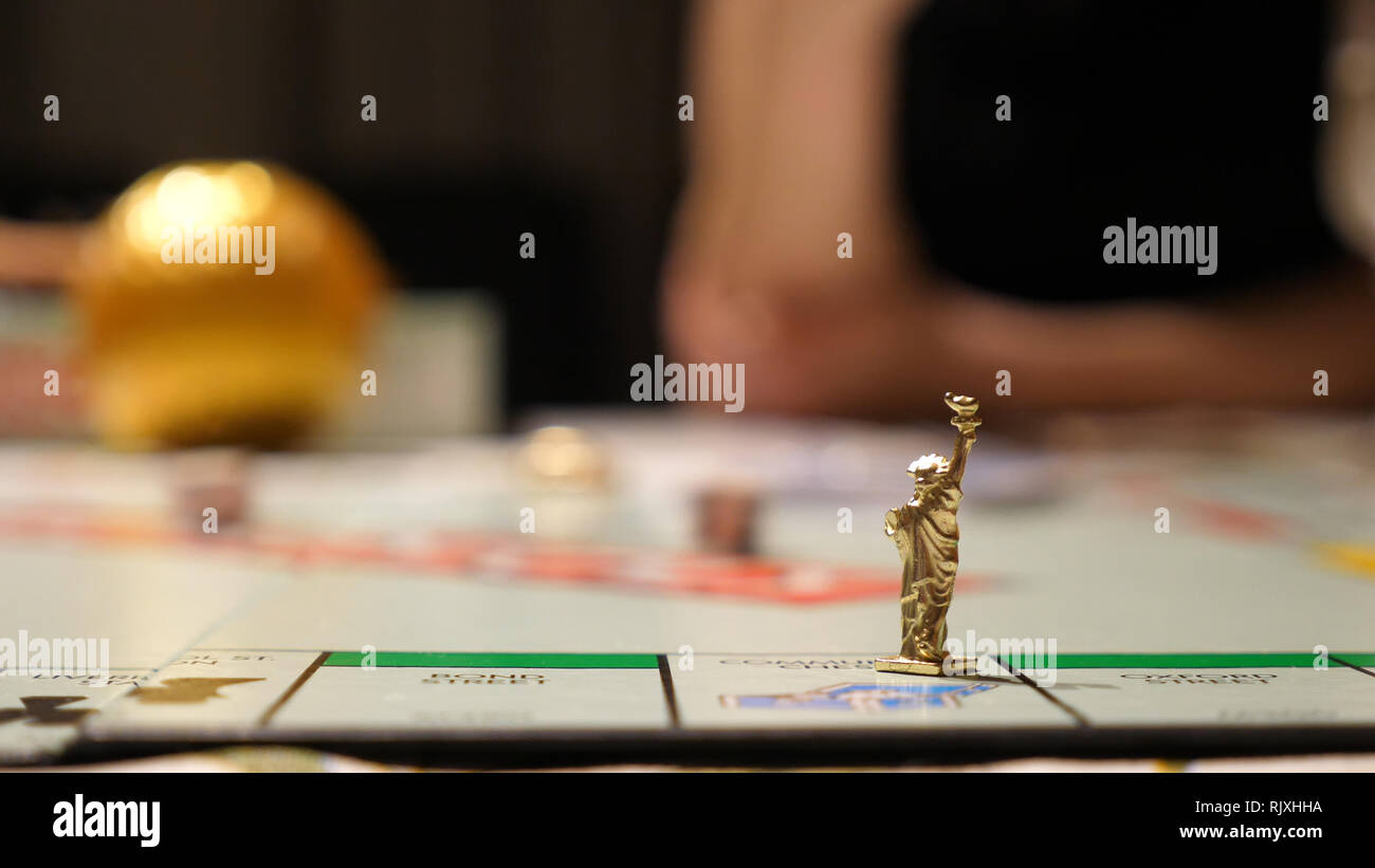 Vista ingrandita della miniatura statua liberty carattere sul gioco desktop mentre la famiglia gioca in casa Foto Stock