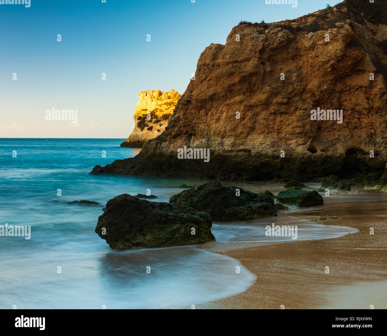 La luce del sole illuminando la formazione di roccia in mare, Alvor, Algarve, Portogallo, Europa Foto Stock