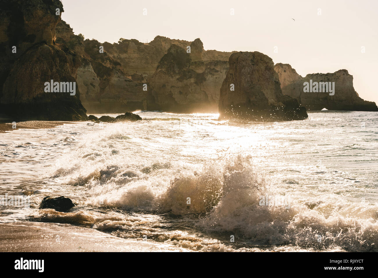 Le onde del mare e la schiuma si infrangono sulla riva, Alvor, Algarve, Portogallo, Europa Foto Stock