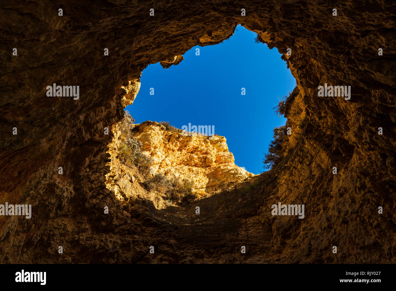 Guardando attraverso l'apertura della grotta di cielo blu, Alvor, Algarve, Portogallo, Europa Foto Stock