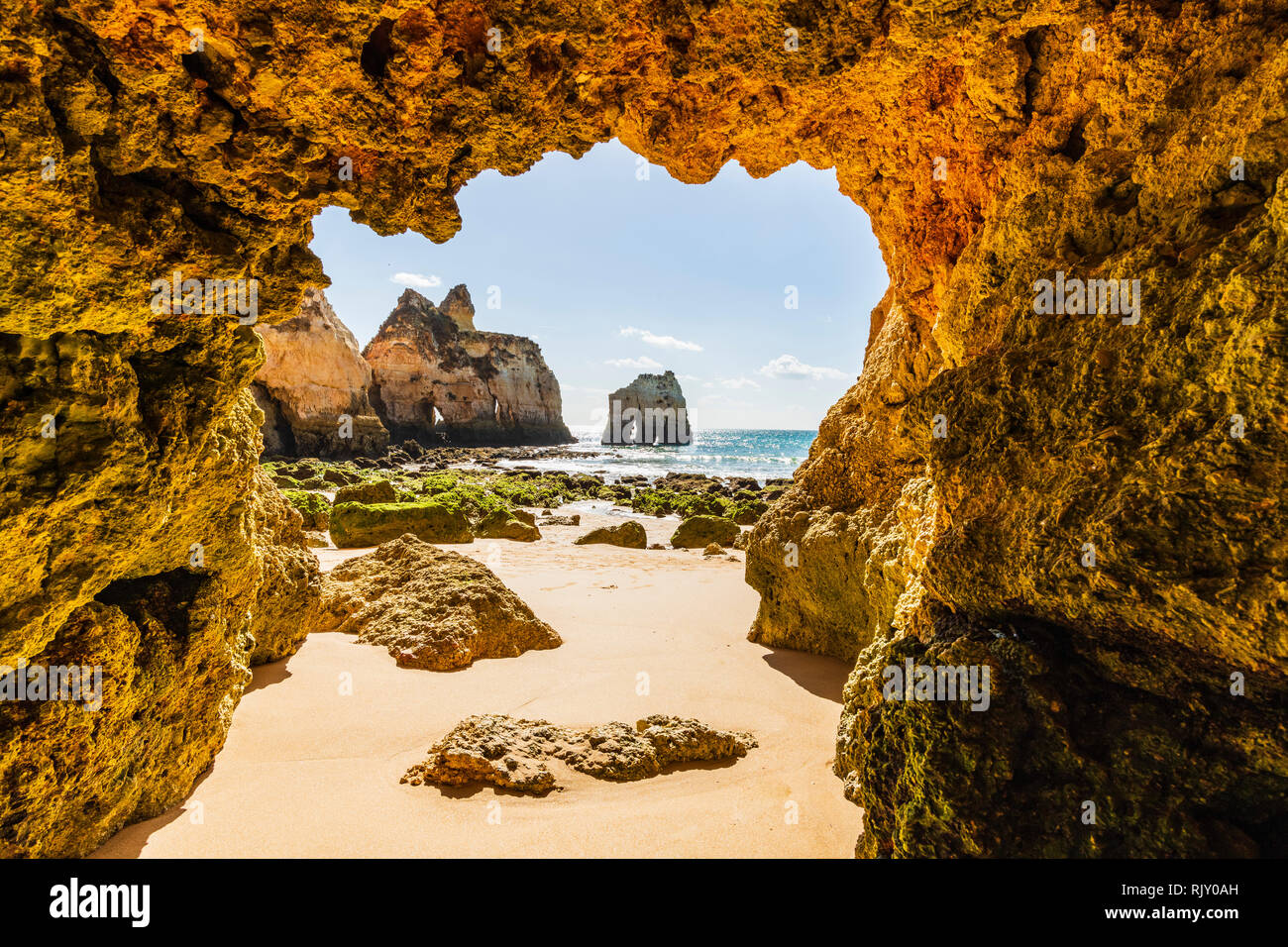 Guardando attraverso arco della grotta verso paesaggi costieri, Alvor, Algarve, Portogallo, Europa Foto Stock