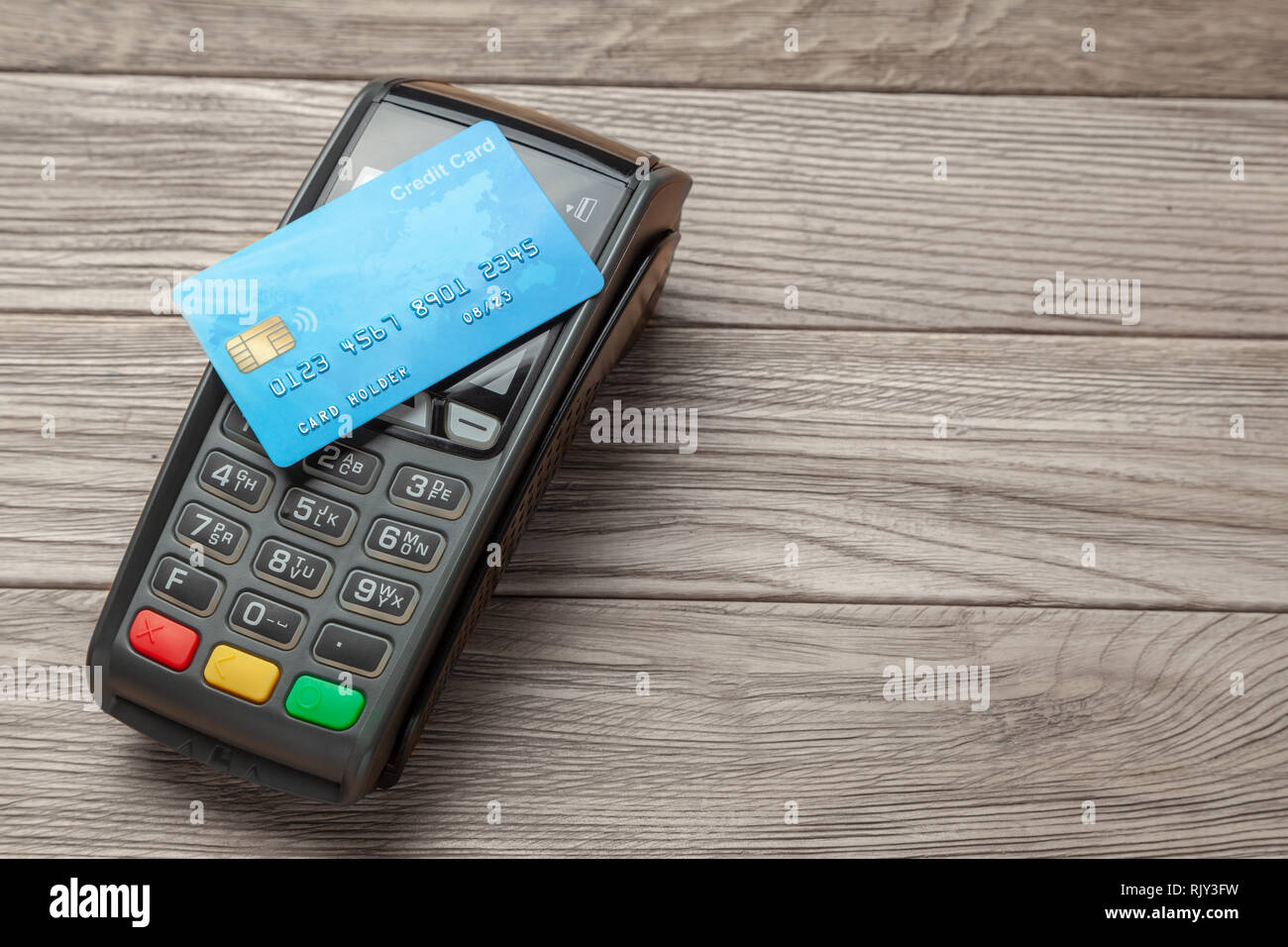 Terminale POS, macchina di pagamento carta di credito su sfondo di legno. Il pagamento senza contatto. La tecnologia NFC. Foto Stock