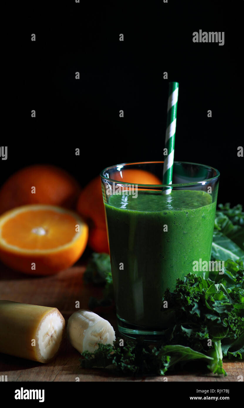 Vetro con kale smoothie con banane e arance fresche Foto Stock