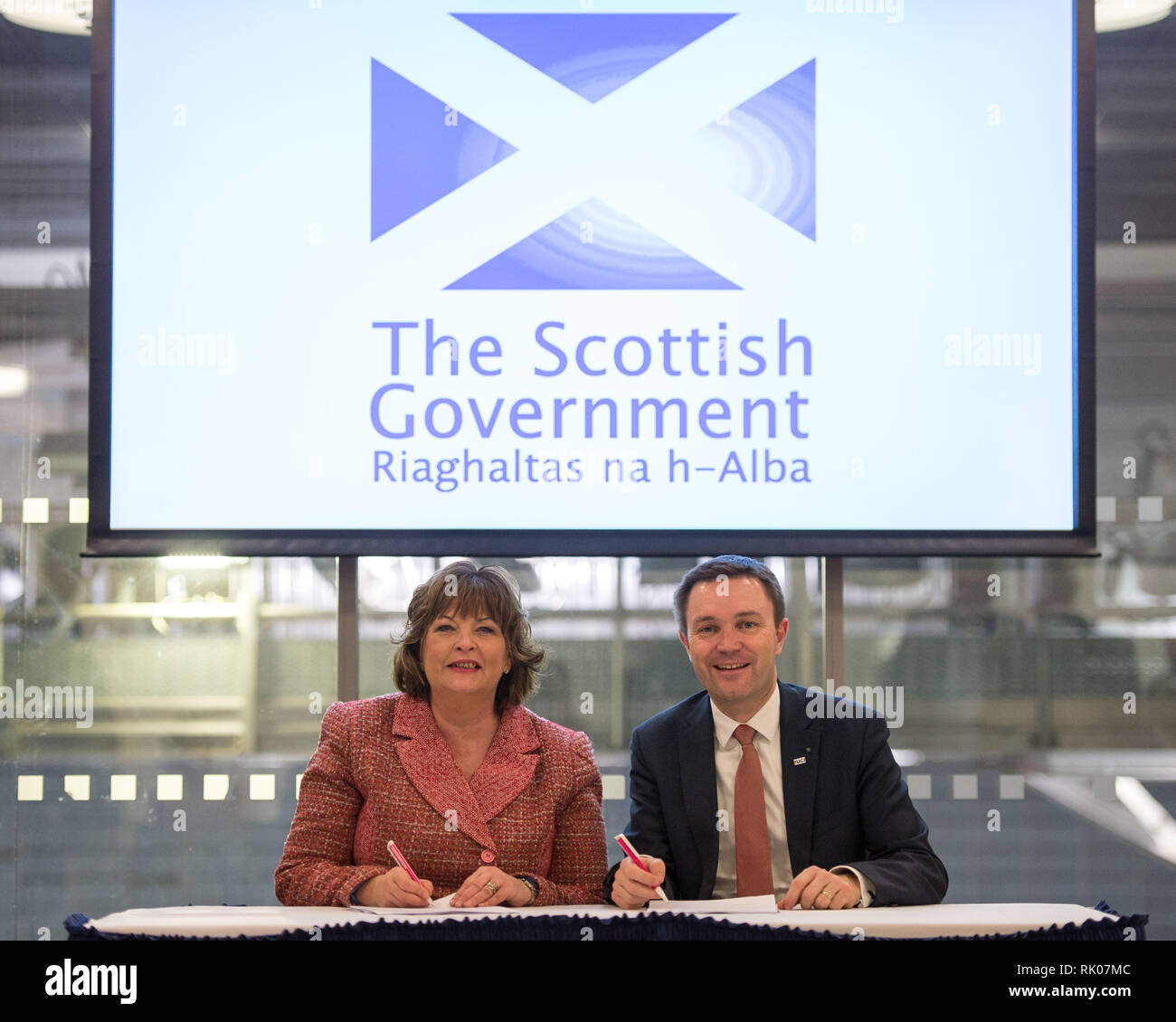 Glasgow, Regno Unito. 8 Feb 2019. (Sinistra) Fiona Hyslop MSP - Armadio Segretario per la cultura, turismo e affari esterni, e (a destra) David Lappartient - Presidente della Union Cycliste Internationale della firma di un accordo. Un nuovo multi-disciplinare, ciclismo manifestazione riunirà 13 UCI esistenti del campionato del mondo di ciclismo in un evento che si terrà ogni quattro anni e per la prima volta a Glasgow e in Scozia nel 2023. Credito: Colin Fisher/Alamy Live News Foto Stock