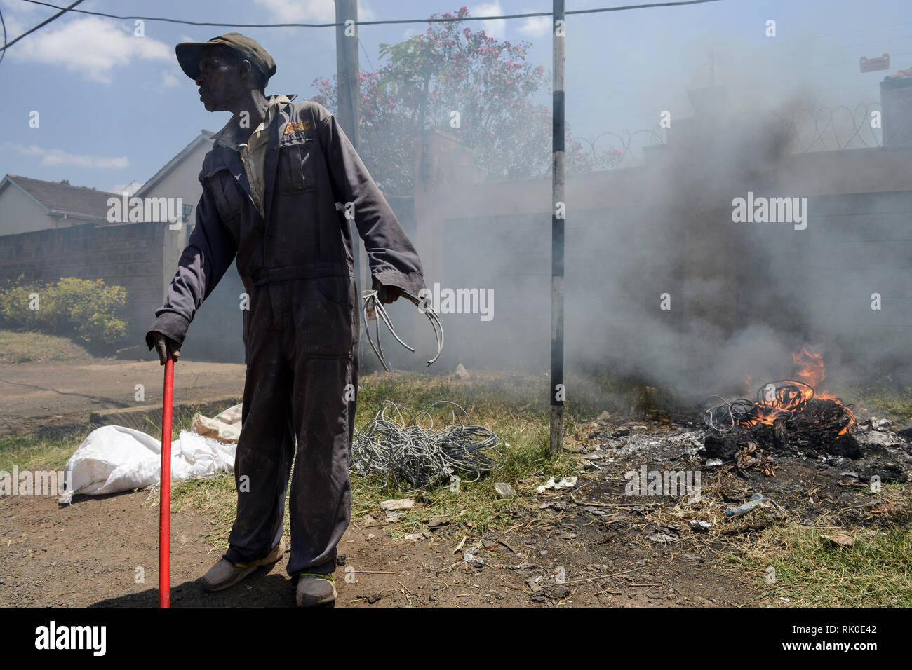 KENYA, Nairobi, centro città, rifiuti picker brucia immondizia e il cavo di isolamento del cavo elettrico sulla strada per raccogliere il rame Foto Stock