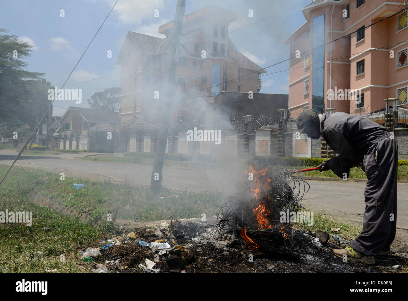 KENYA, Nairobi, centro città, rifiuti picker brucia immondizia e il cavo di isolamento del cavo elettrico sulla strada per raccogliere il rame Foto Stock