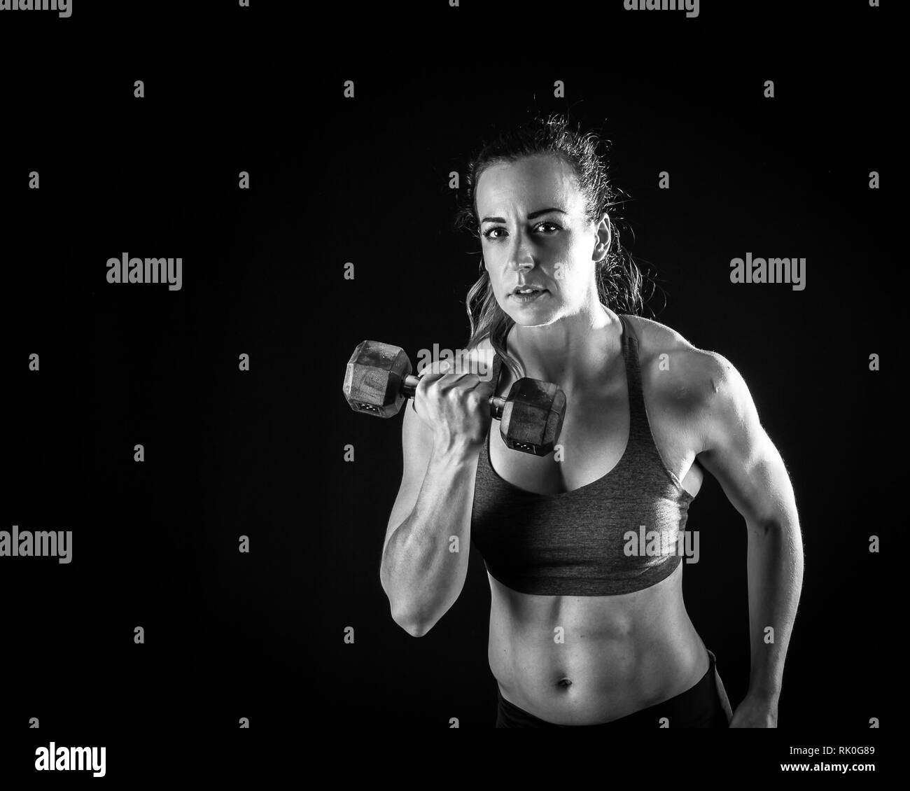 Signor atleta femminile con pesi in attrezzature fitness Foto Stock