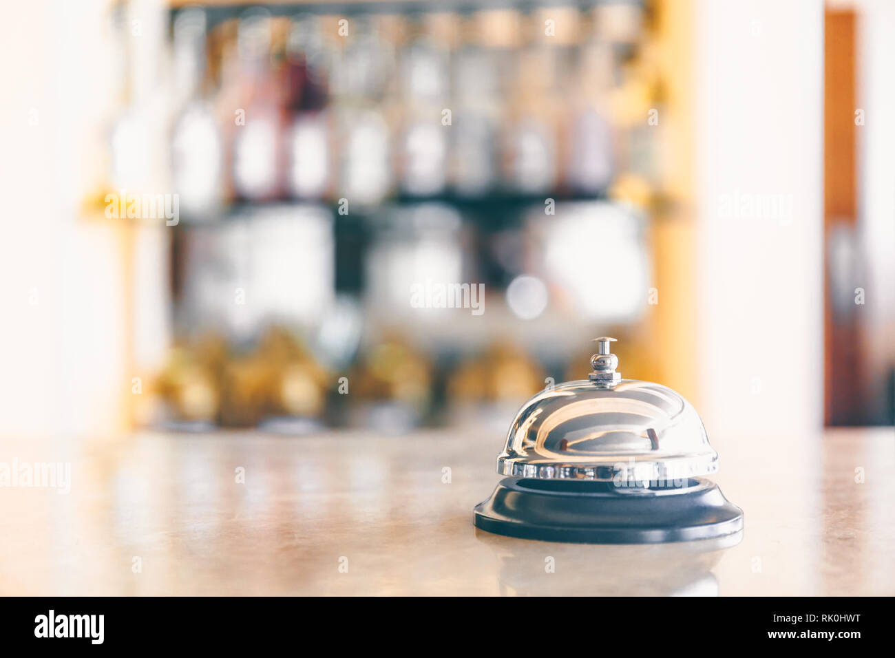 Campanello di chiamata personale sul supporto. La reception e il bar dello sfondo. Vacanze e viaggi concetto. Orizzontale, selettiva tonificante a freddo Foto Stock