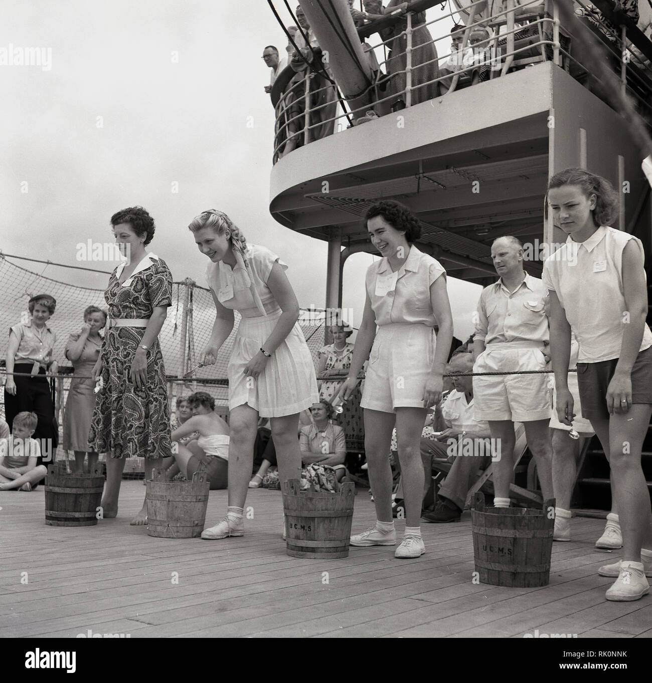 Degli anni Cinquanta, storico, femmina i passeggeri con piccole botti di legno accanto a loro di prendere parte un gioco di coperta a bordo di un battello a vapore Union-Caste. Foto Stock