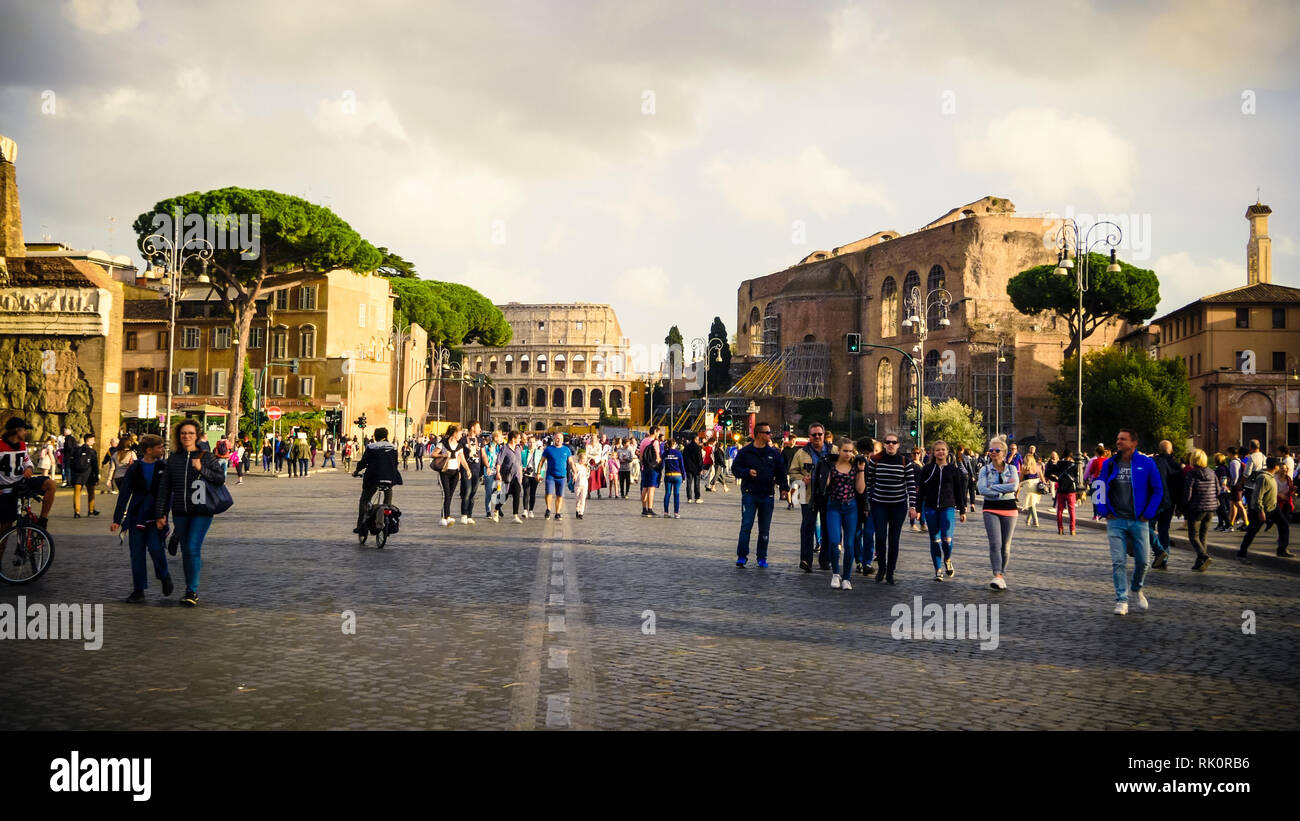 I turisti a piedi lungo la Via dei Fori Imperiali con il Colosseo a Roma Foto Stock