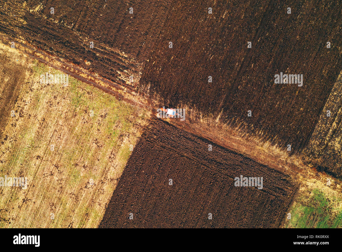 Vista aerea del trattore agricolo campo di aratura in autunno freddo pomeriggio da fuco pov Foto Stock