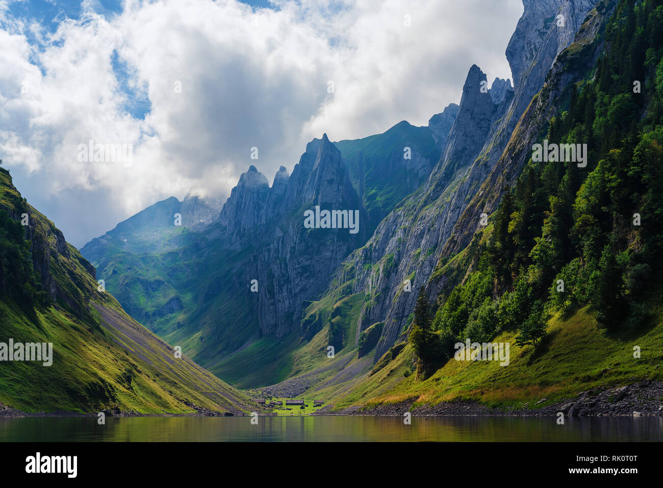 Paesaggio di montagna delle Alpi svizzere con cime frastagliate e un blu incontaminato lago di montagna nella valle di gran lunga al di sotto. Foto Stock