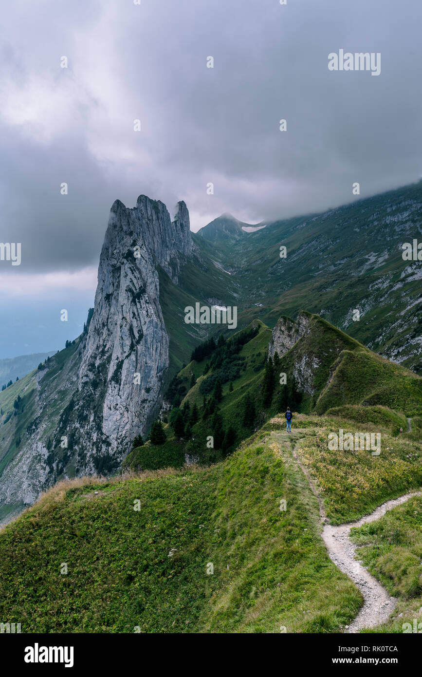 Paesaggio di montagna delle Alpi svizzere con cime frastagliate e un blu incontaminato lago di montagna nella valle di gran lunga al di sotto. Foto Stock