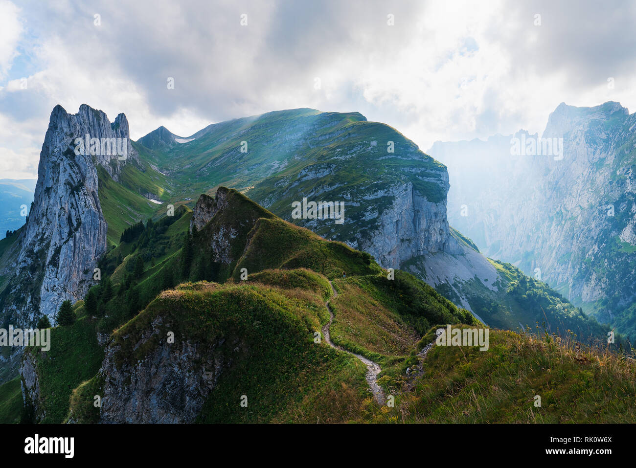 Paesaggio di montagna delle Alpi svizzere con cime frastagliate e un blu incontaminato lago di montagna nella valle di gran lunga al di sotto. Foto Stock