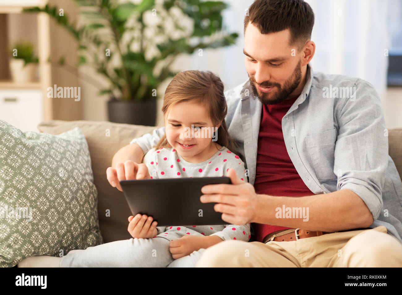 Padre e figlia con tablet pc a casa Foto Stock