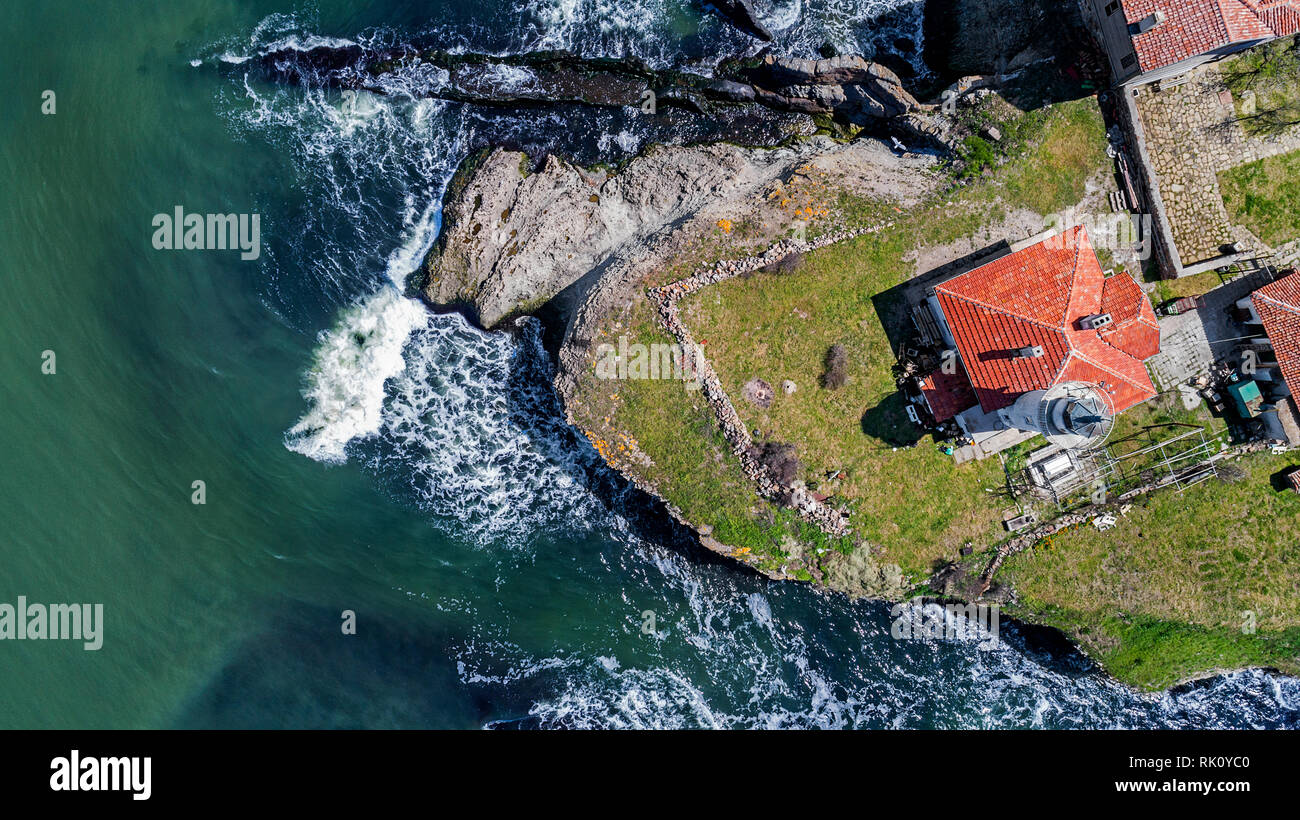 Santa Anastasia isola nella baia di Burgas, Mar Nero, Bulgaria. Torre faro e vecchi edifici in legno sulla costa rocciosa Foto Stock