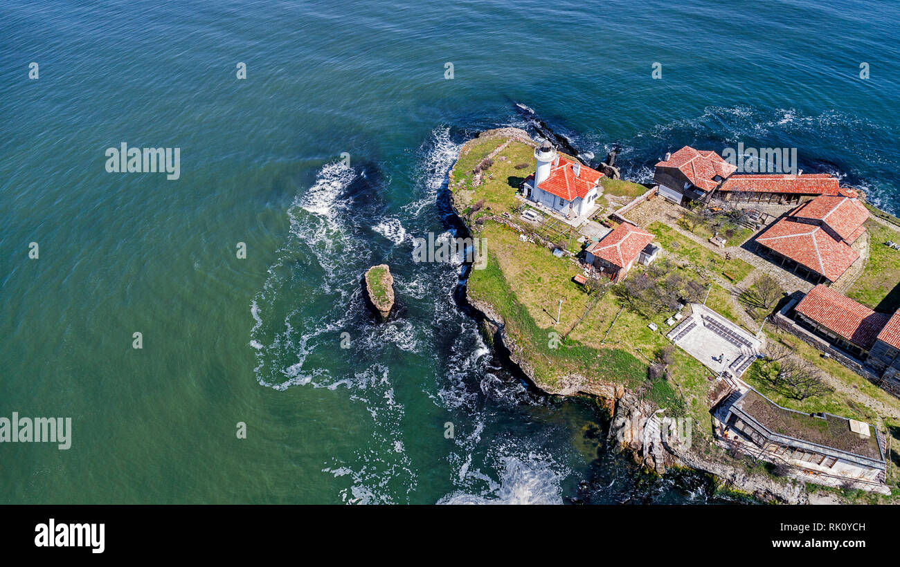 Santa Anastasia isola nella baia di Burgas, Mar Nero, Bulgaria. Torre faro e vecchi edifici in legno sulla costa rocciosa Foto Stock