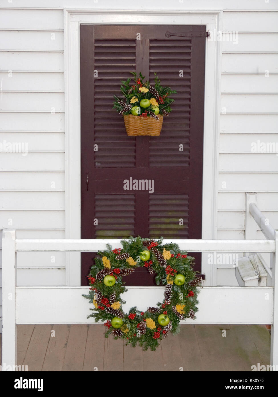 Decorazioni di Natale, corona sulla ringhiera; matching cesto su porta; frutta, fiori, pigne, sempreverdi, festosa, vacanze, Colonial Williamsburg; VA Foto Stock