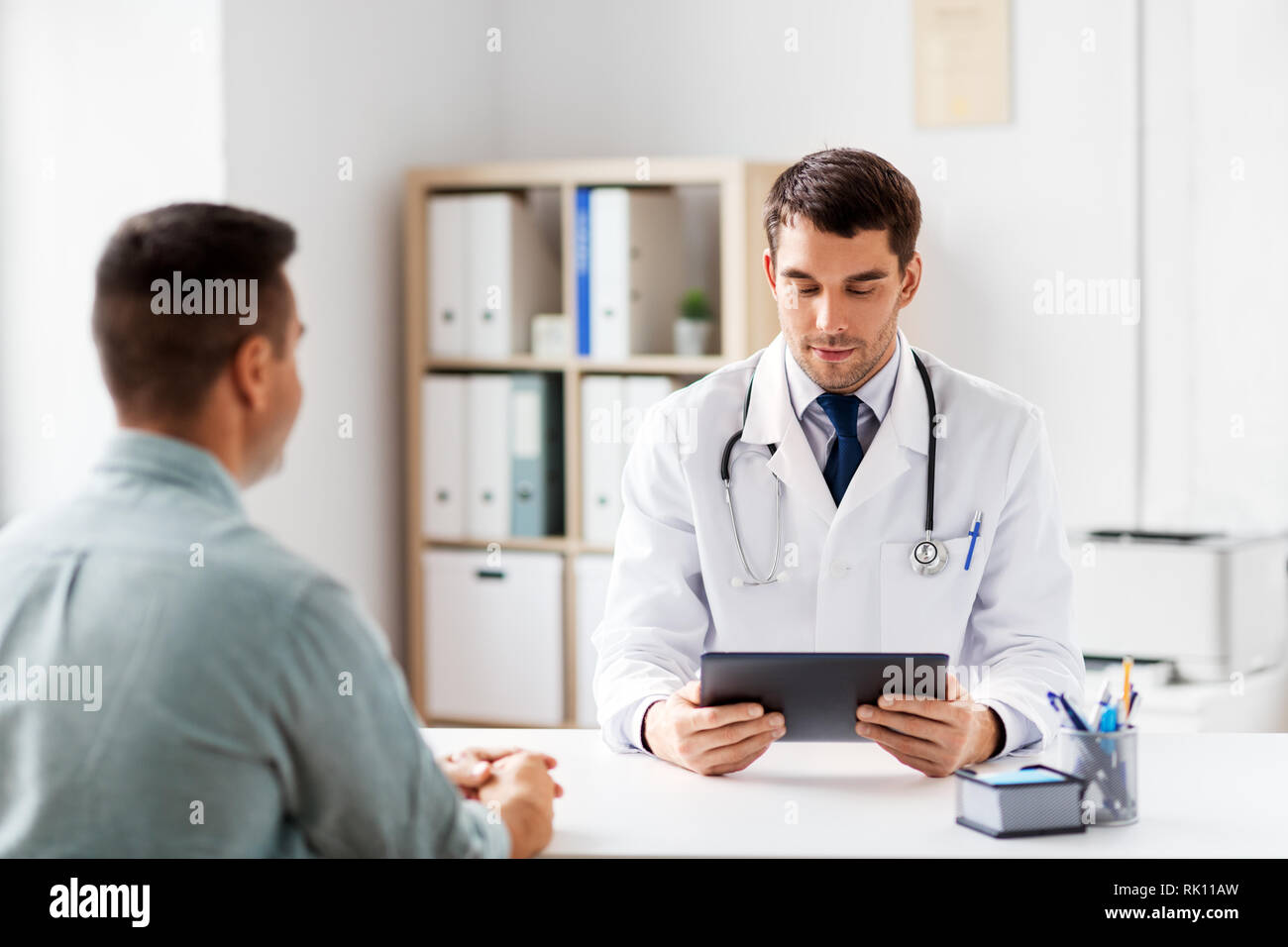 Medico con computer tablet e paziente presso la clinica Foto Stock