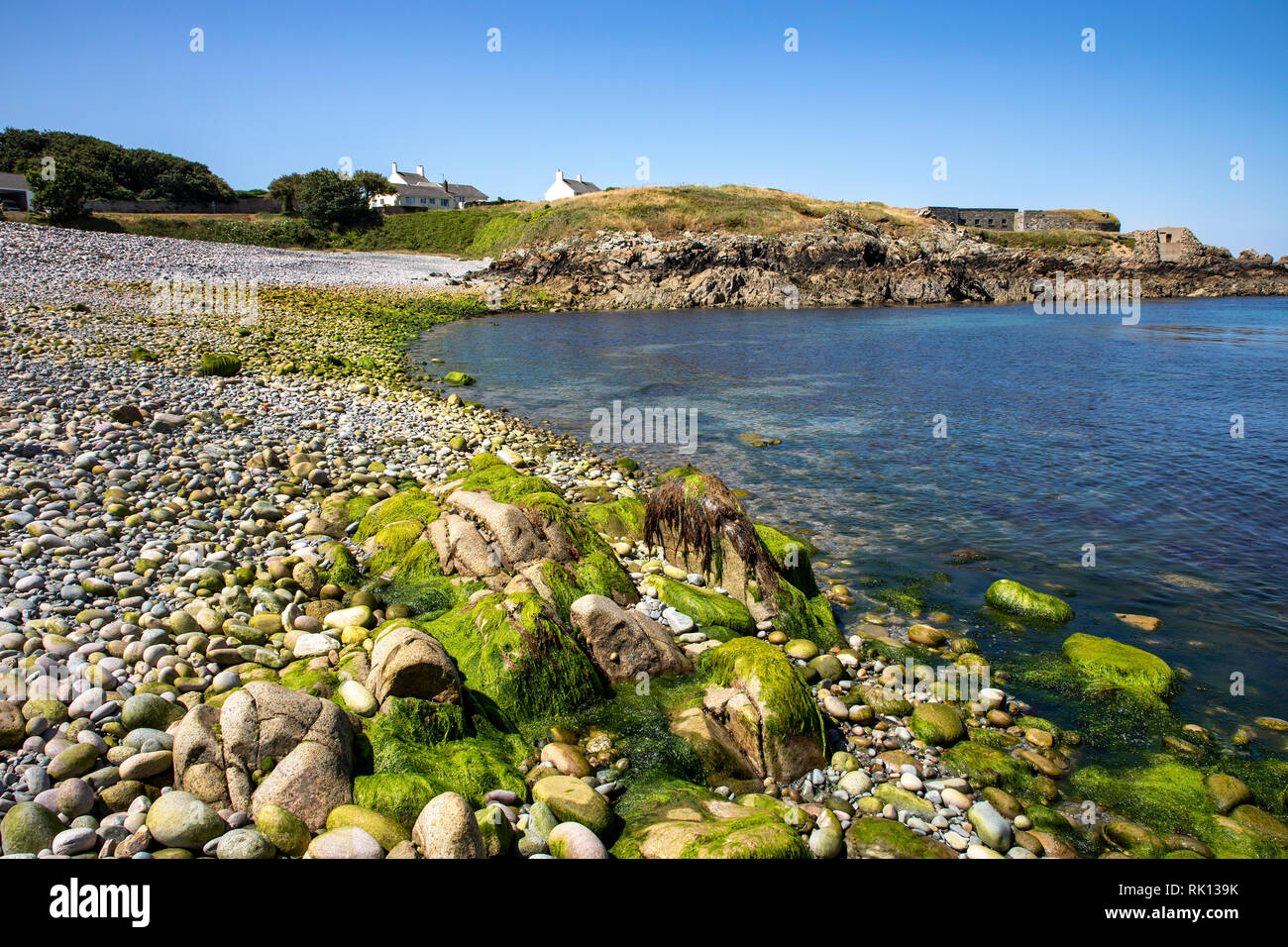 Vista verso Fort Doyle lungo la spiaggia scontrosa su Alderney Isole del Canale. Foto Stock