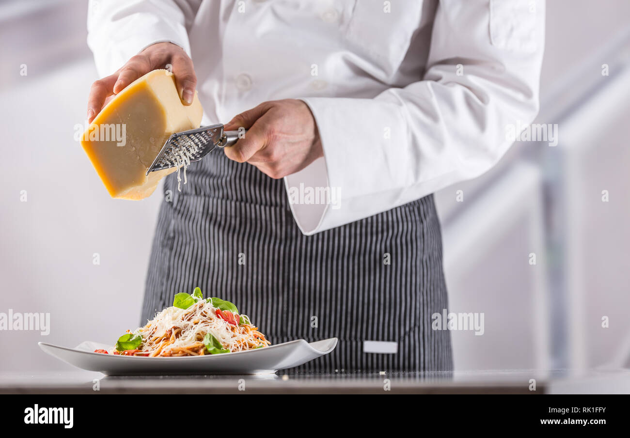 Lo chef del ristorante cucina preparata pasto italiano spaghetti e parmigiano grattugiato. Foto Stock