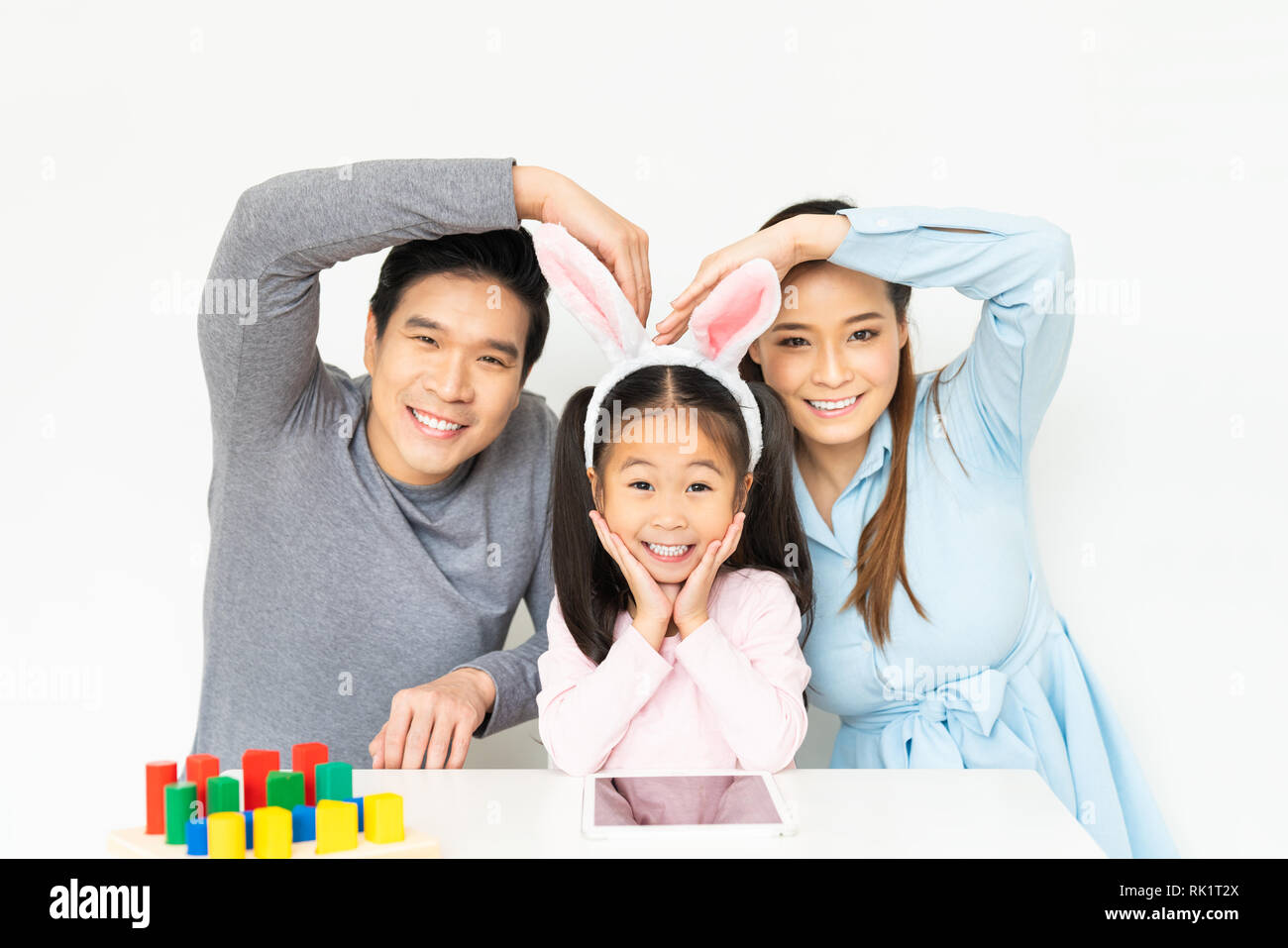 Giovane bella famiglia asiatica, genitori e piccola ragazza di capretto facendo pongono divertenti e sorridente insieme a casa. La famiglia felice amore concetto Foto Stock
