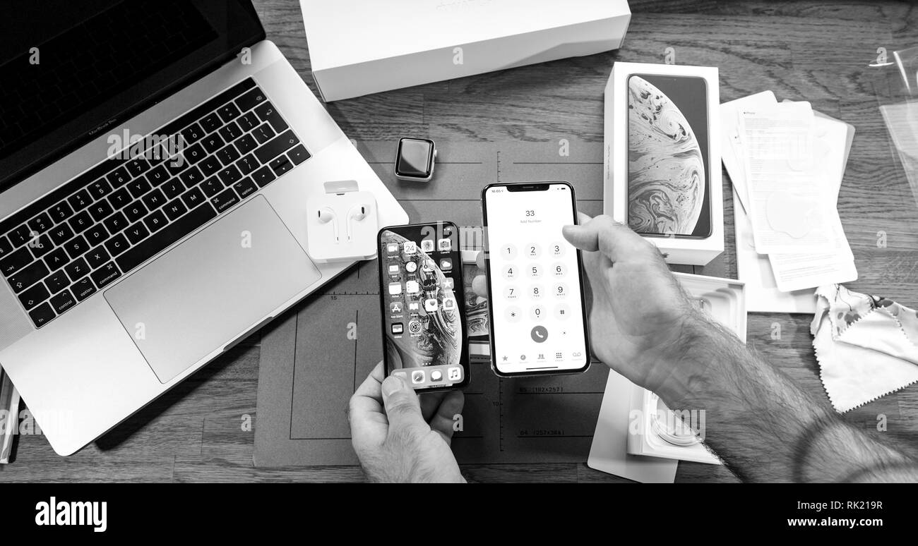 Parigi, Francia - 21 settembre 2018: uomo unboxing ultime nuovo Apple Iphone Xs Max e Xs smartphone ammiraglia modello di telefono cellulare da computer Apple confrontando due smartphone dimensioni - in bianco e nero Foto Stock