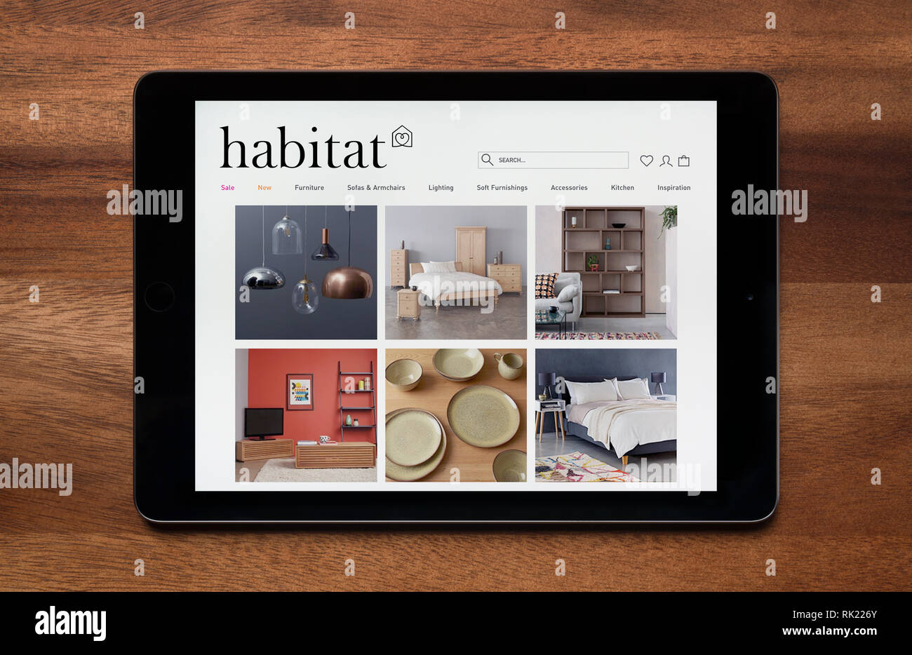 Il sito web di Habitat è visto su un tablet iPad, il quale è appoggiato su un tavolo di legno (solo uso editoriale). Foto Stock