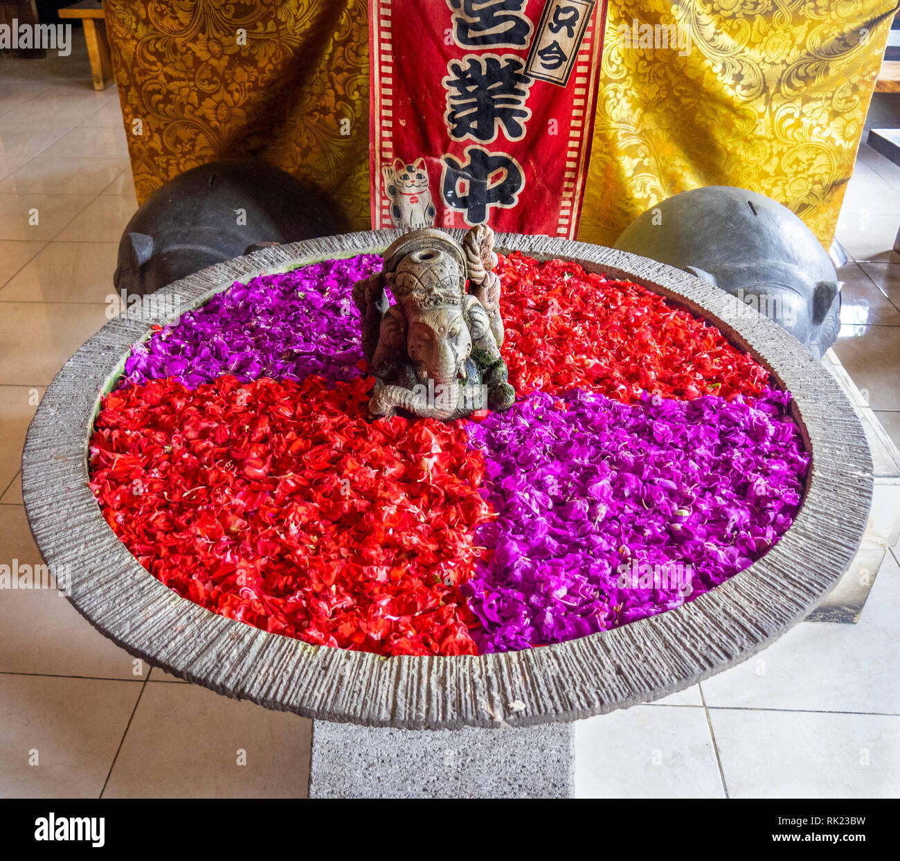 L'urna piena di rosso magenta e petali di fiori in Jimbaran, Bali Indonesia. Foto Stock