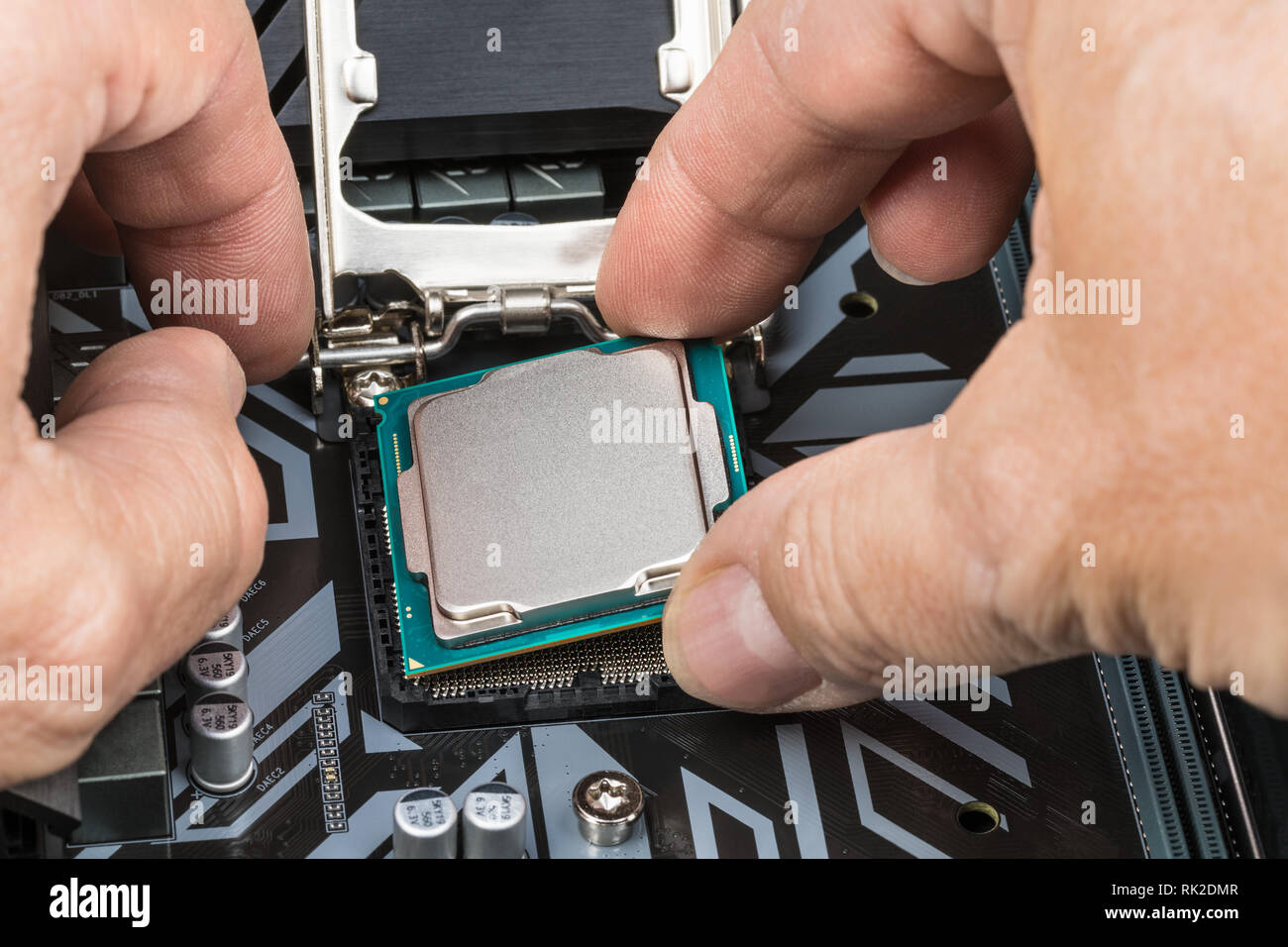 Dettaglio di mani esperte in sostituzione del processore. Installazione di unità di elaborazione centrale nel socket della scheda madre del computer. PC hardware manutenzione. Foto Stock