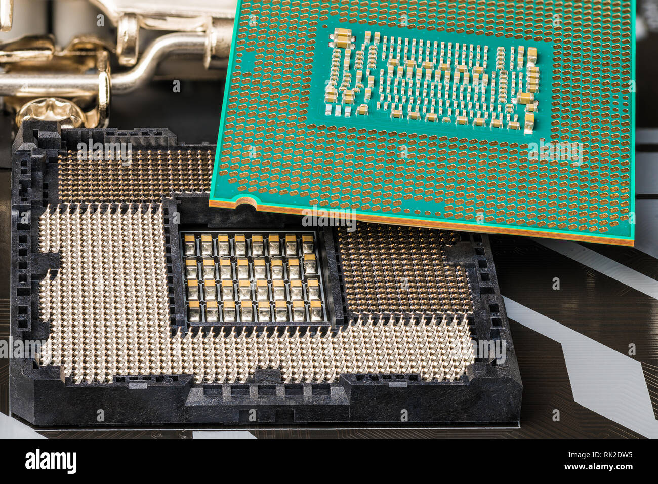 Installazione del processore nel socket sulla scheda madre del computer. Close-up di unità centrale di elaborazione. Sostituzione di componenti hardware. Dettaglio del microchip. Foto Stock