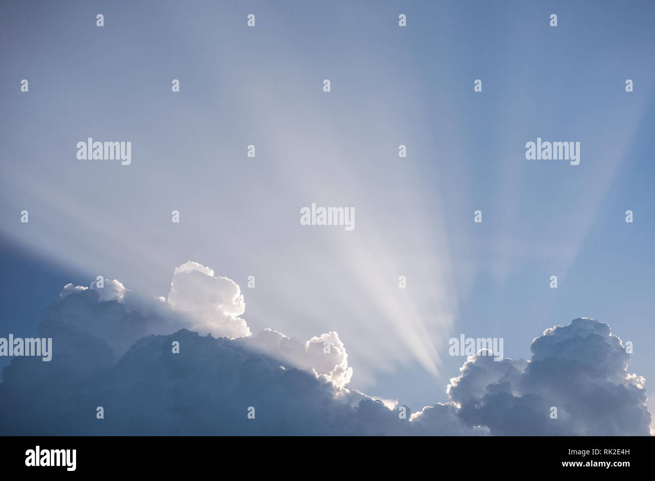 Bella nuvoloso cielo blu e la mattina presto morbida luce del sole dietro soffici nuvole bianche. La bellezza della natura. Orizzontale fotografia a colori. Foto Stock