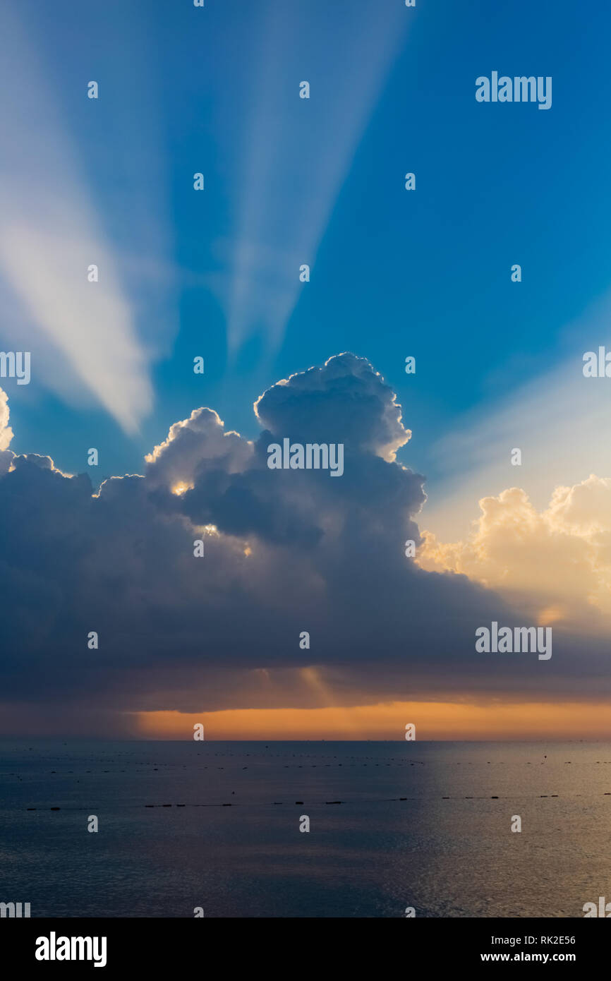 Bellissimo paesaggio marino con incantevoli soft sunray, mattina enorme soffici nuvole e cielo blu. Verticale fotografia a colori. Foto Stock