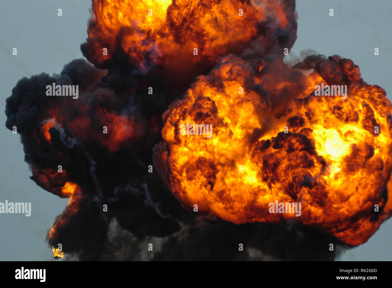 Enorme eruzione di fuoco, esplosione pirotecnica. Fiamme. Fuoco caldo e fumo nero intenso. Simulando l'esplosione di una bomba Foto Stock