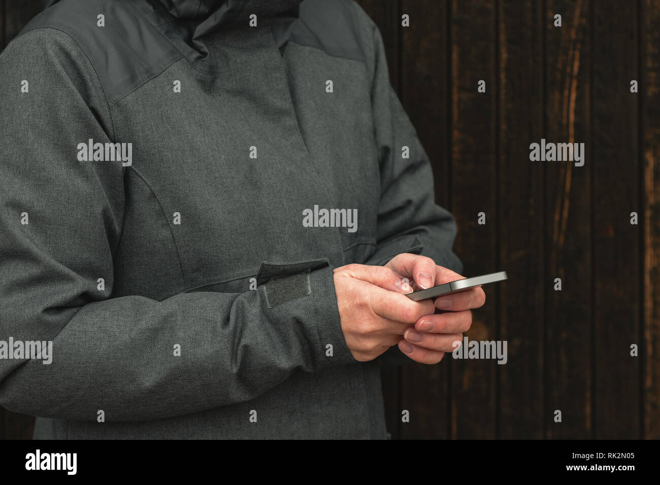 Casual è femmina texting messaggio sul telefono mobile su strada in inverno freddo pomeriggio, close up delle mani Foto Stock