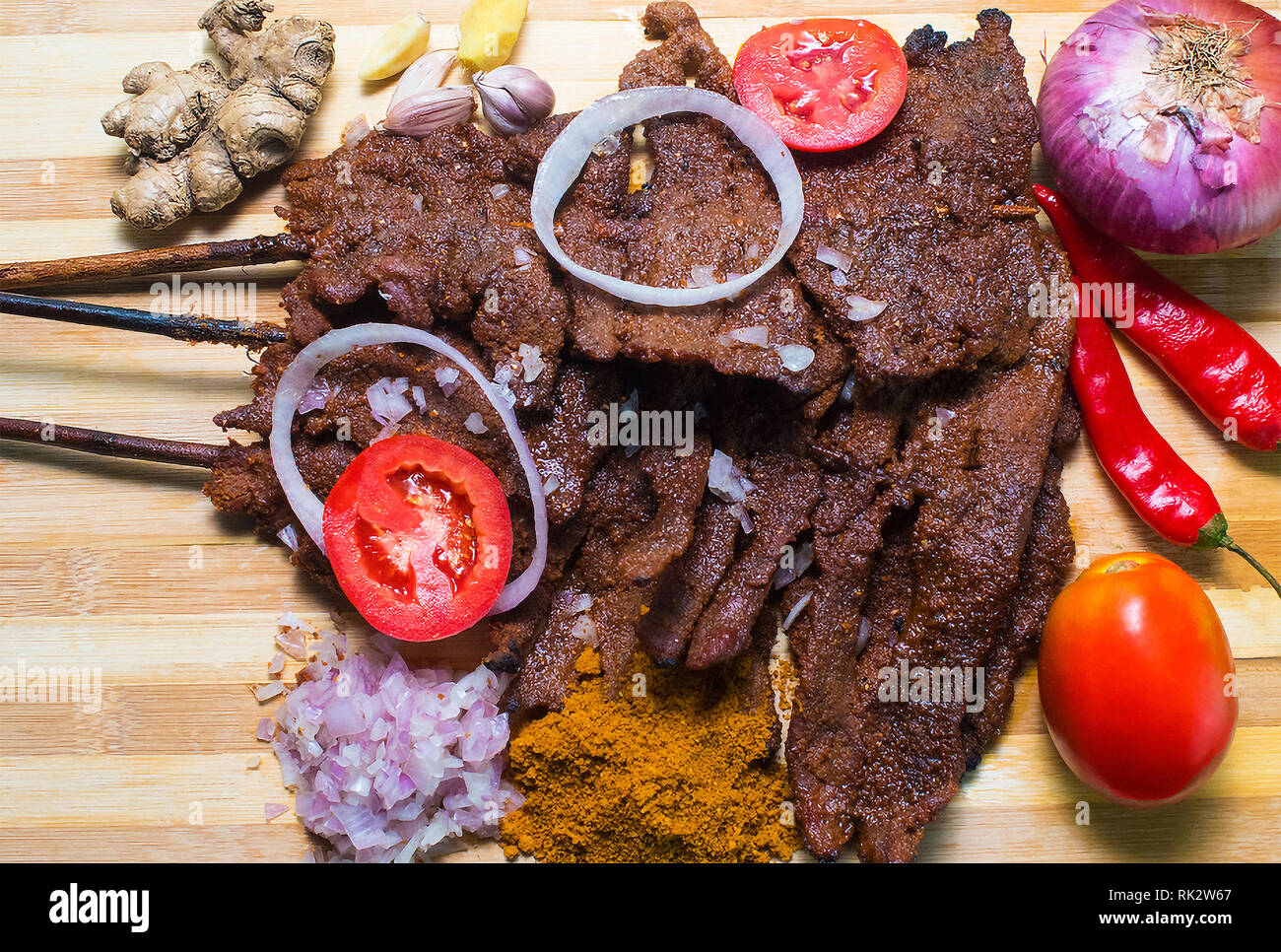 Popolari piatti nigeriani - grigliate di carni bovine Suya con assortimento di verdure per guarnire Foto Stock