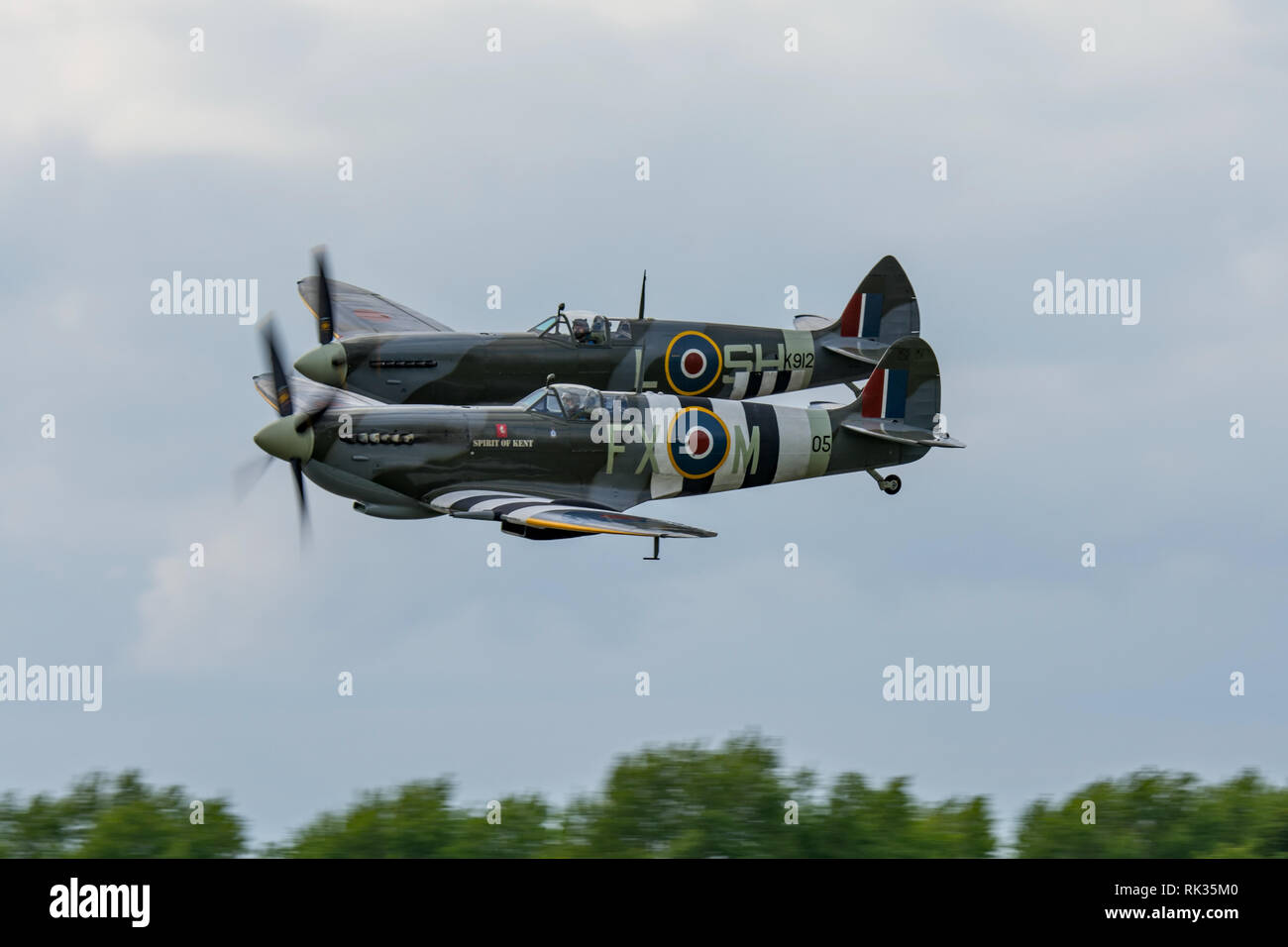 Due WW2 Supermarine Spitfire combattenti battenti in stretta formazione a basso livello sopra Biggin Hill Airfield,Kent, Regno Unito il 13 giugno 2015. Foto Stock