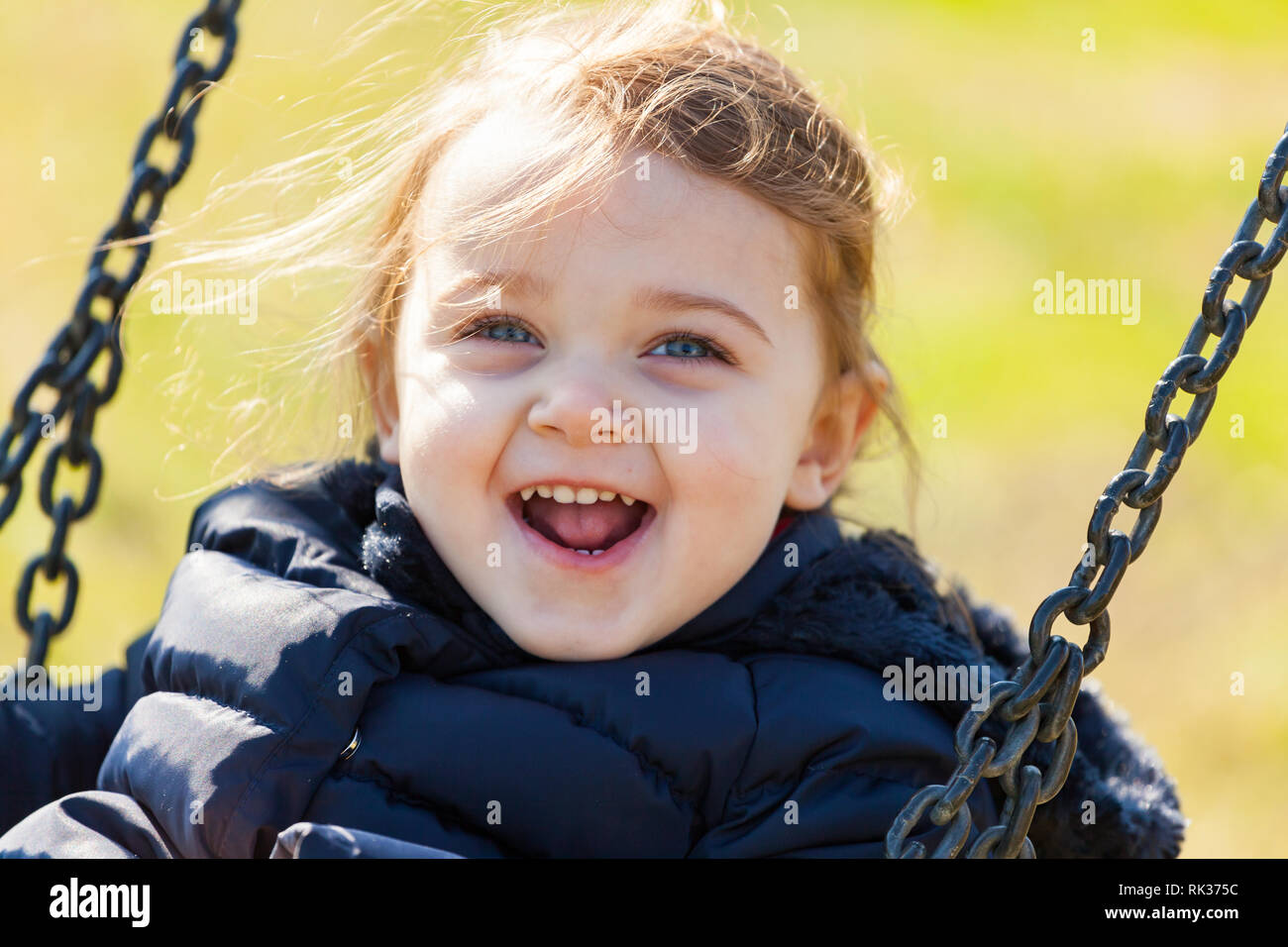 Bella ragazza toddler divertirsi su altalena nel parco. Foto Stock