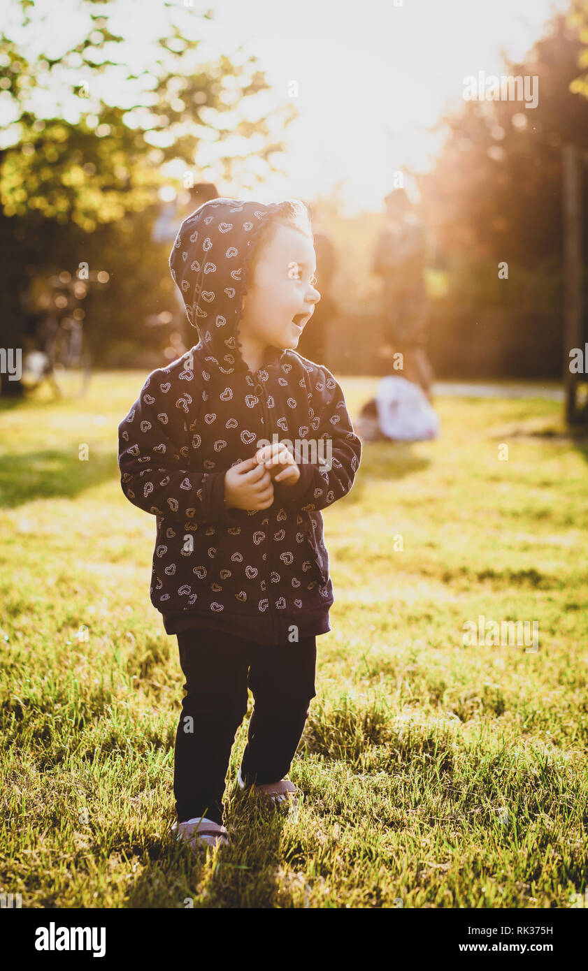 Bella ragazza toddler divertirsi nel parco in una giornata autunnale. Foto Stock