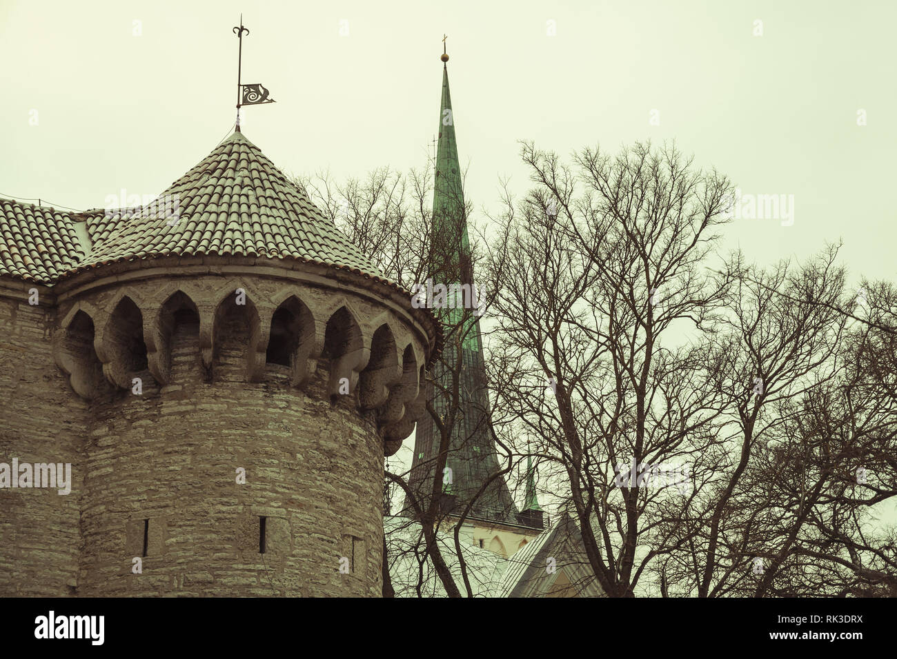 Vecchia skyline di Tallinn con torre in pietra e la guglia di san Olaf Chiesa, Estonia. Vintage foto stilizzata con tonale filtro di correzione Foto Stock