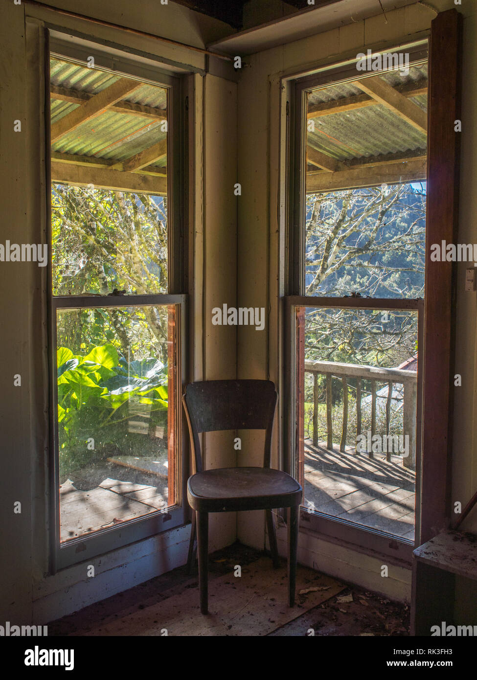 Sedia vuota in un angolo da windows, di sole sulla veranda, casa abbandonata, Ahu Ahu Ohu, Whanganui River, Nuova Zelanda Foto Stock