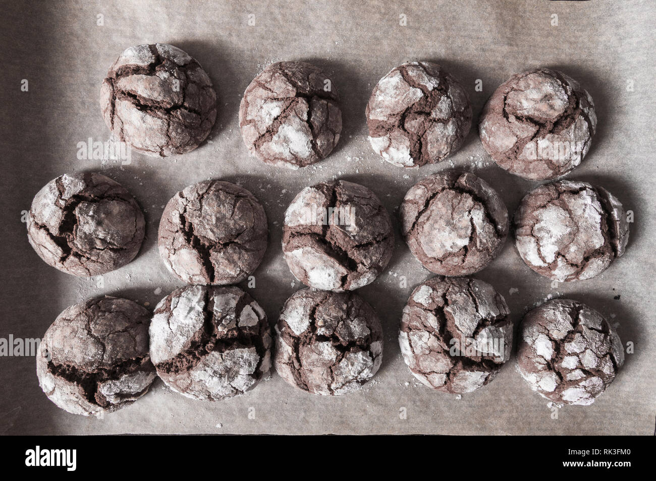 Appena sfornato biscotti al cioccolato con aprire le crepe e bagnatela con zucchero a velo giacciono su un brucia ancora deck. Vista superiore Foto Stock