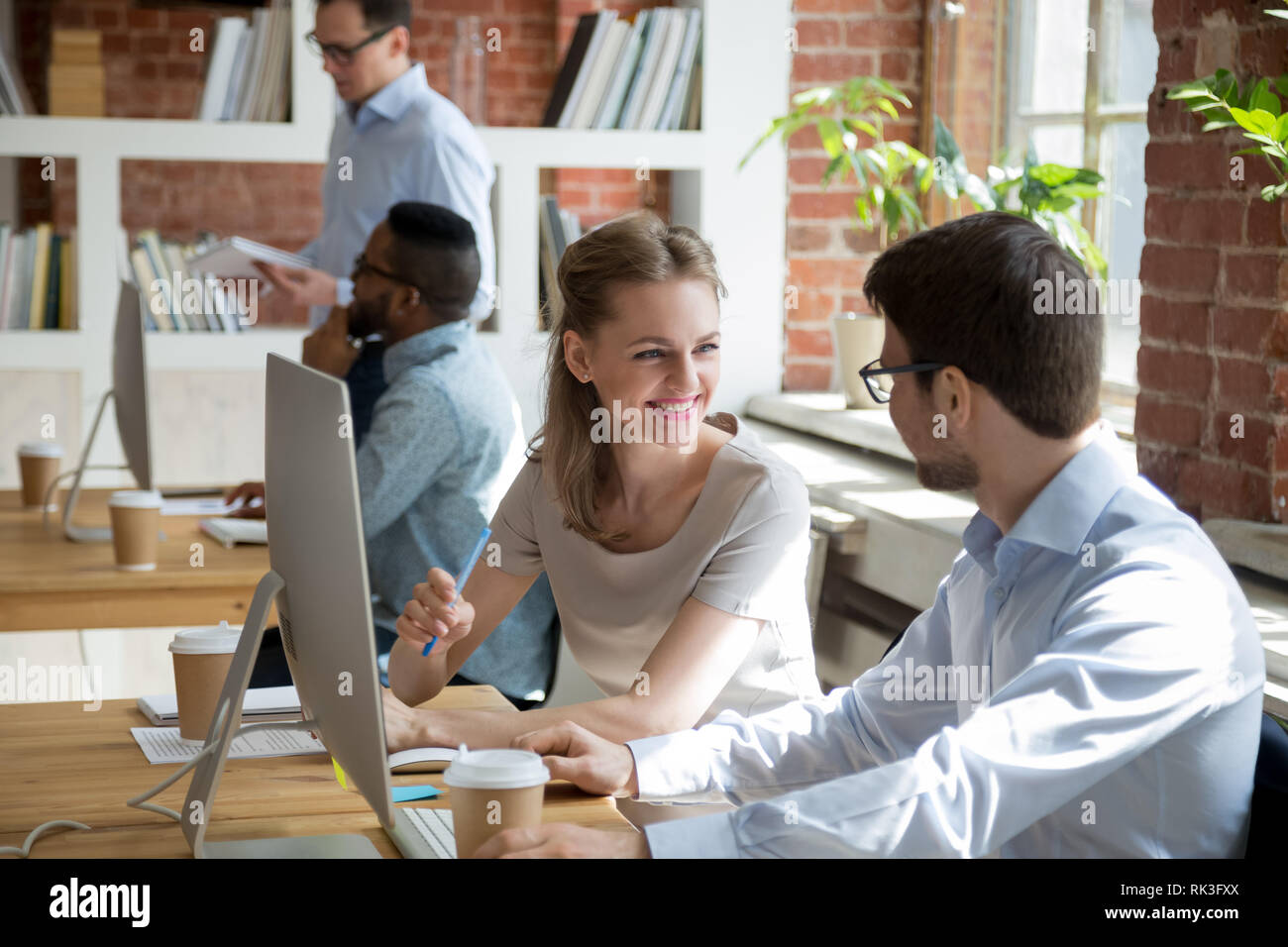 Amichevole maschio e femmina avente i colleghi conversazione parlando di office Foto Stock