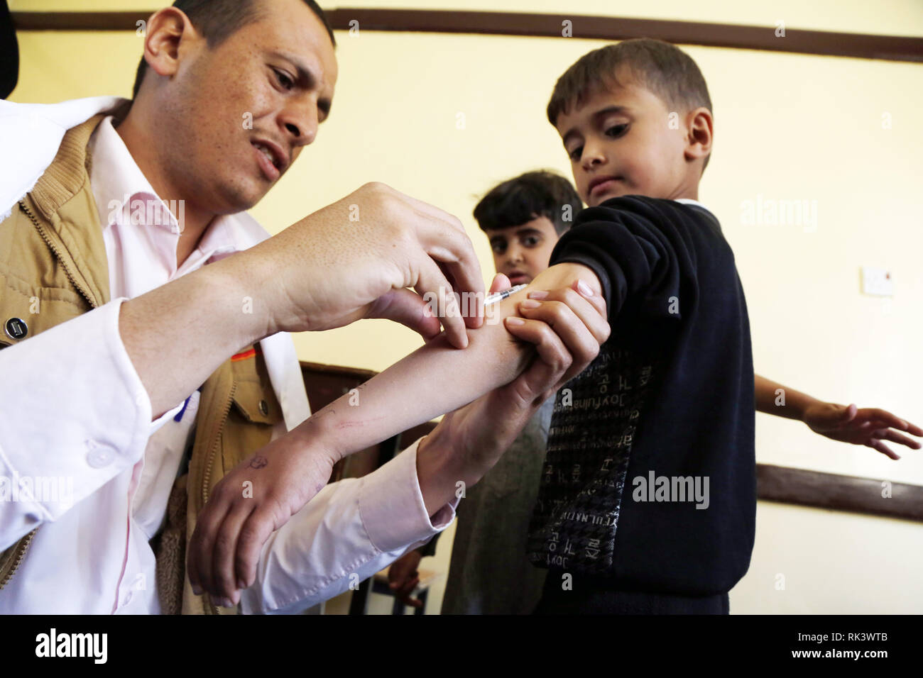 Sanaa, Yemen. Il 9 febbraio, 2019. Un medic dà un bambino un anti-morbillo e rosolia vaccino ad un centro di vaccinazione in Sanaa, Yemen, Febbraio 9, 2019. Un cittadino il morbillo e la rosolia campagna di immunizzazione sono iniziate il sabato in Yemen e avrà la durata di sei giorni. Il target della campagna yemenita ai bambini dai sei mesi ai 15 anni, secondo i media locali. Credito: Mohammed Mohammed/Xinhua/Alamy Live News Foto Stock